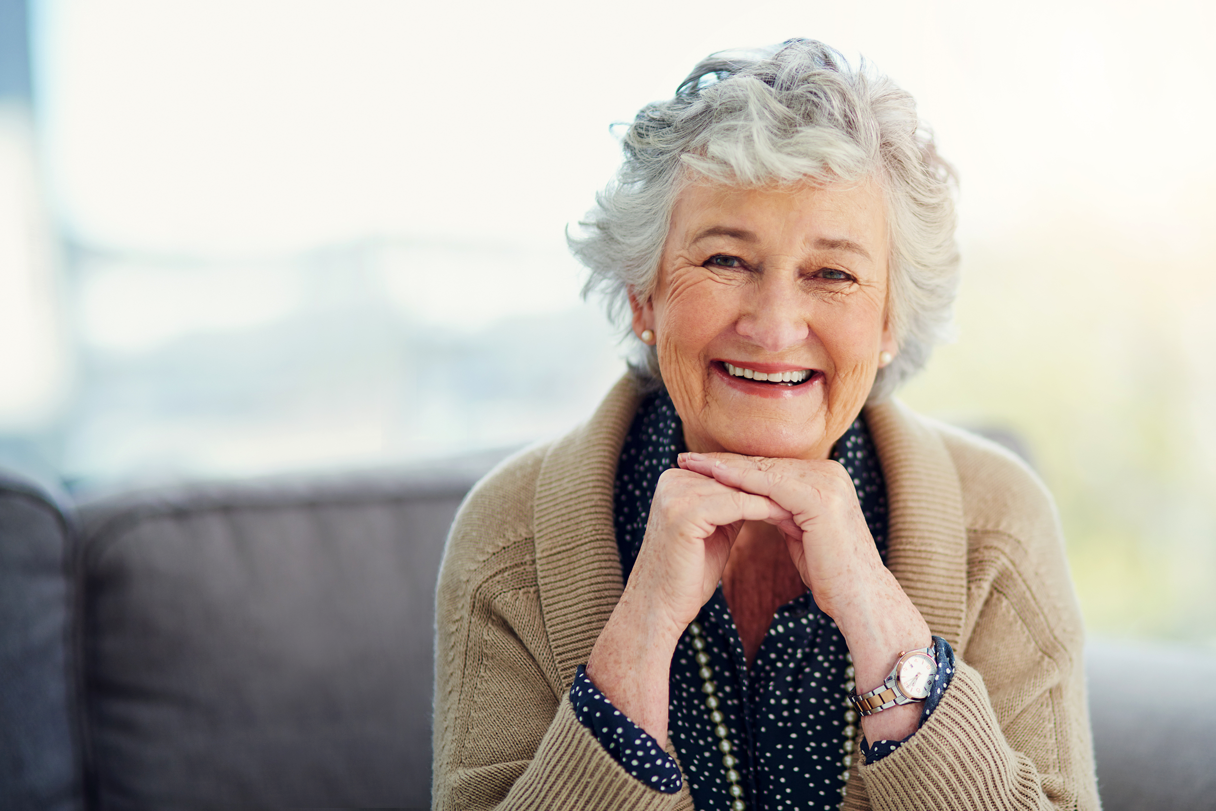 Happy senior woman with her hands under her chin