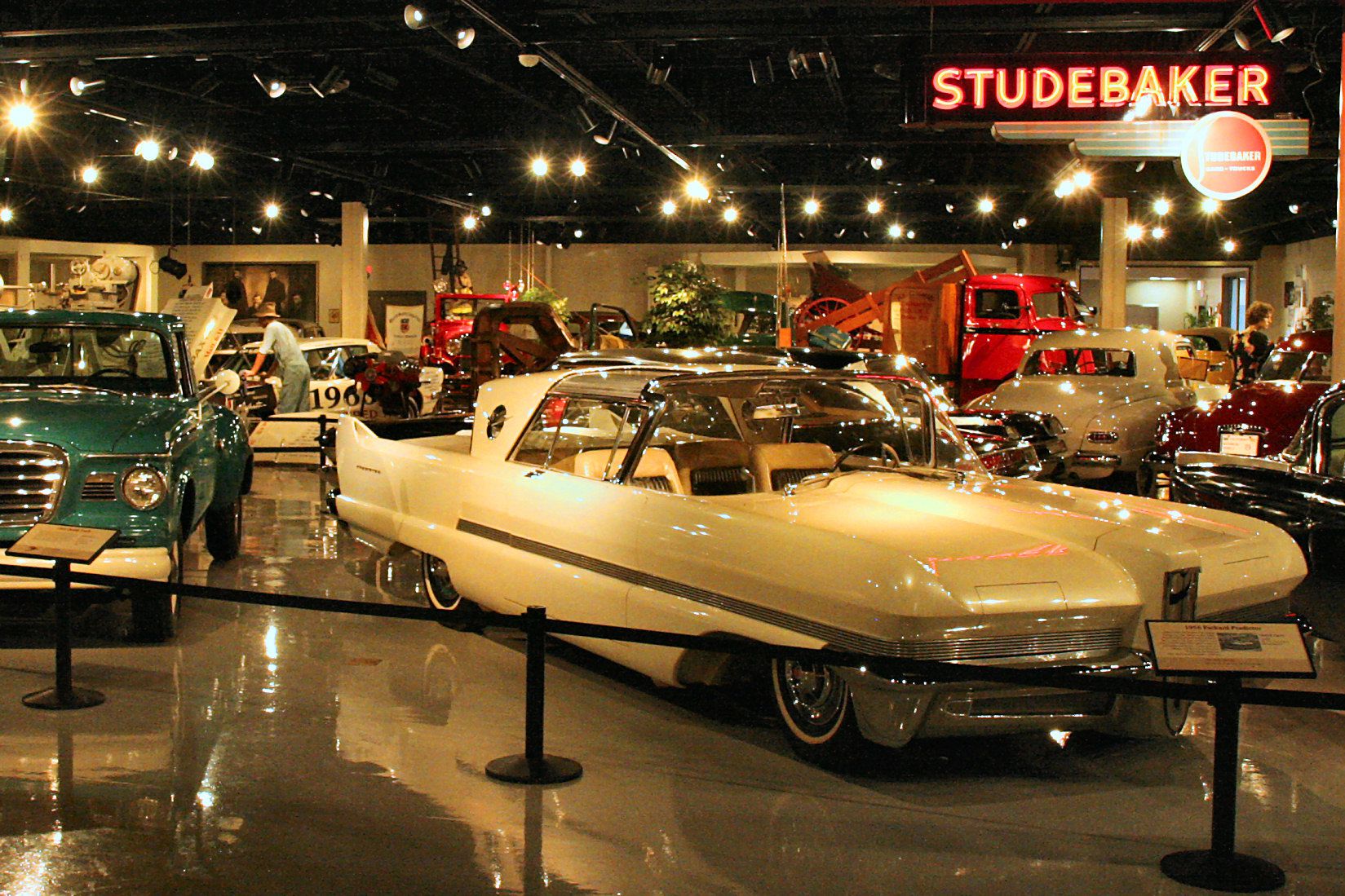 Studebaker Museum, South Bend, Indiana, stylish vintage cars from the 1950s and 60s showcased with bright lighting, shiny concrete flooring, shiny cars