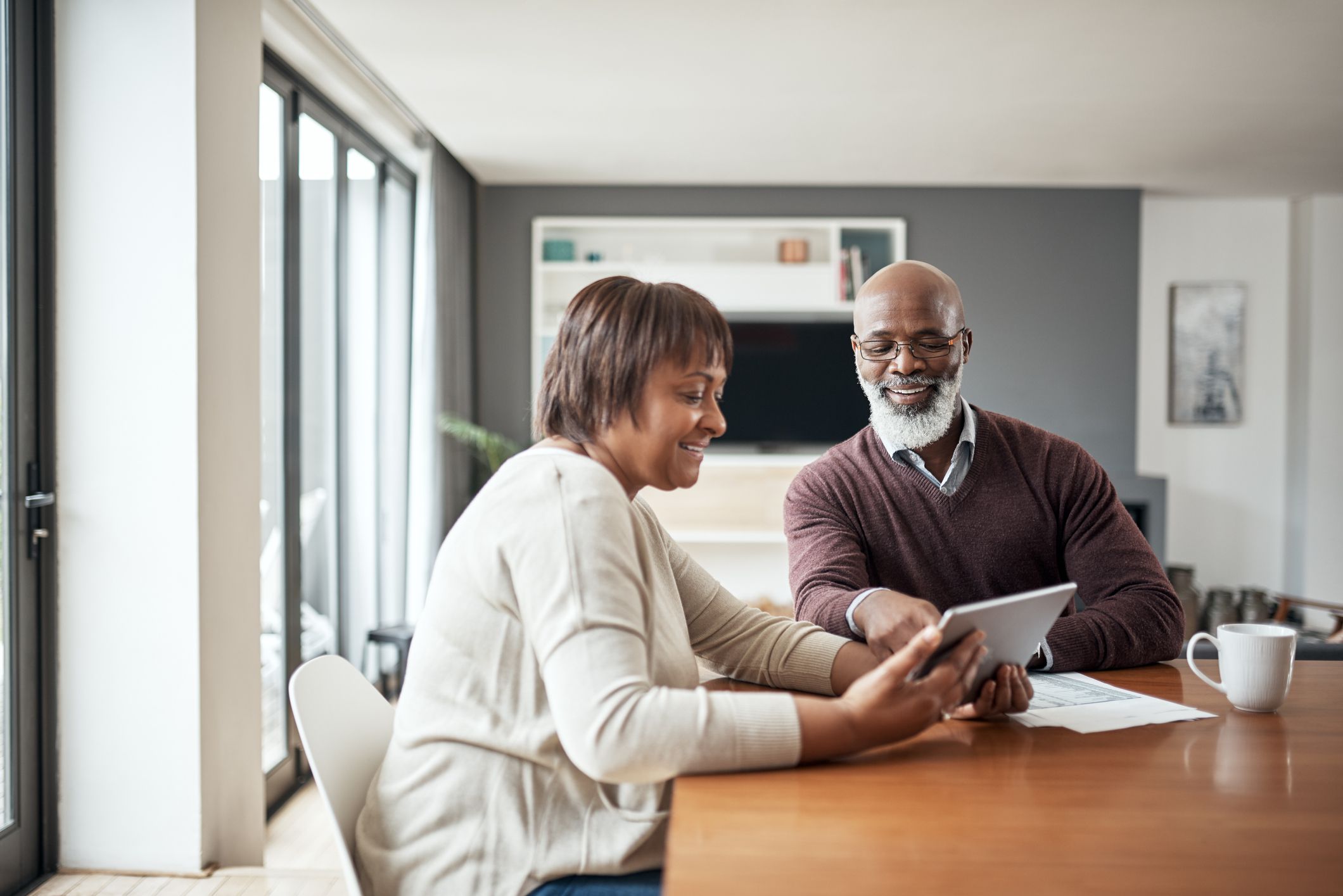 Cropped shot of a happy senior couple sitting together and using a tablet to go through their financial budgets