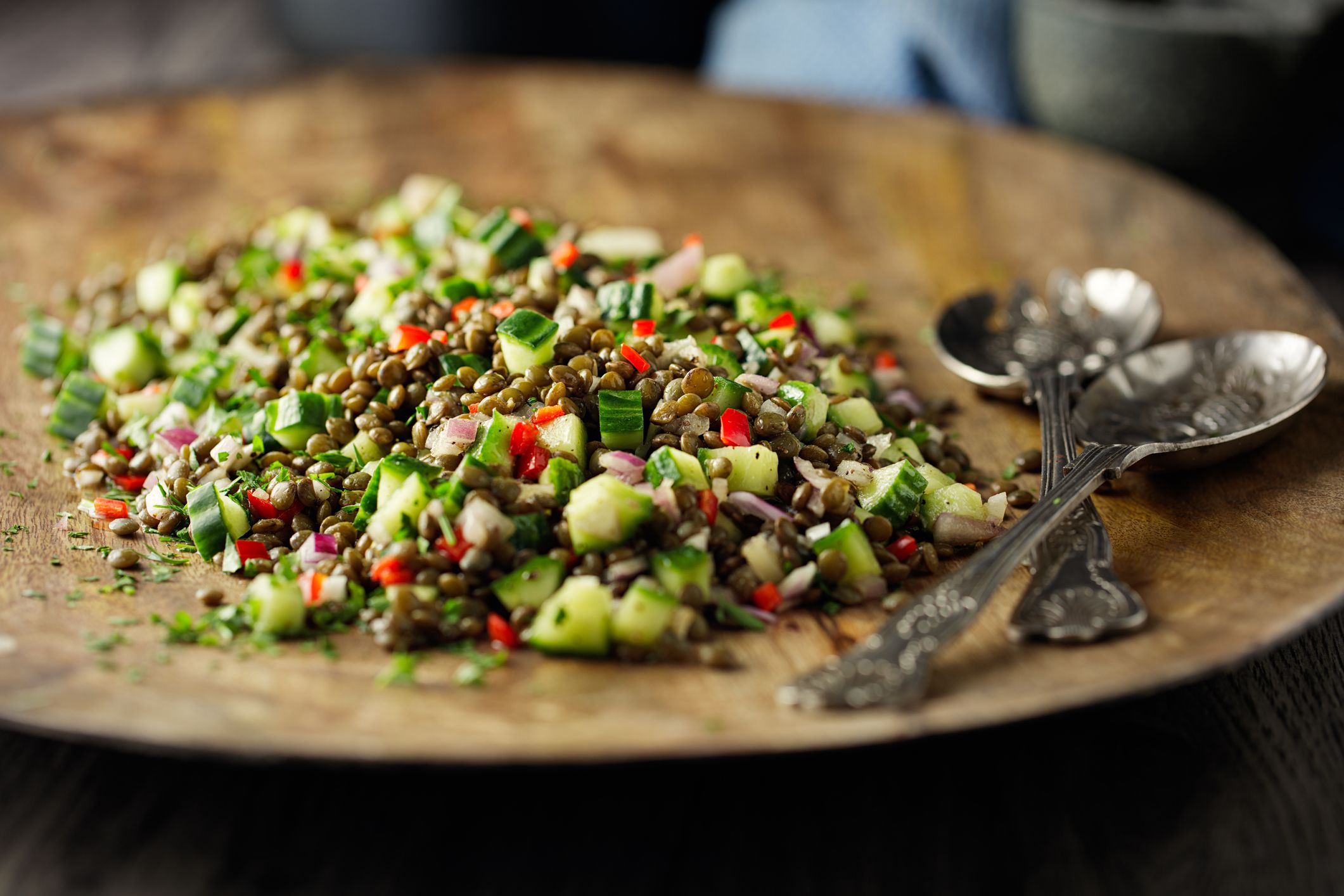 Home made freshness green lentils,cucumber,red chilli with English mustard olive oil dressing and fine chopped parsley on wooden plate for servicing