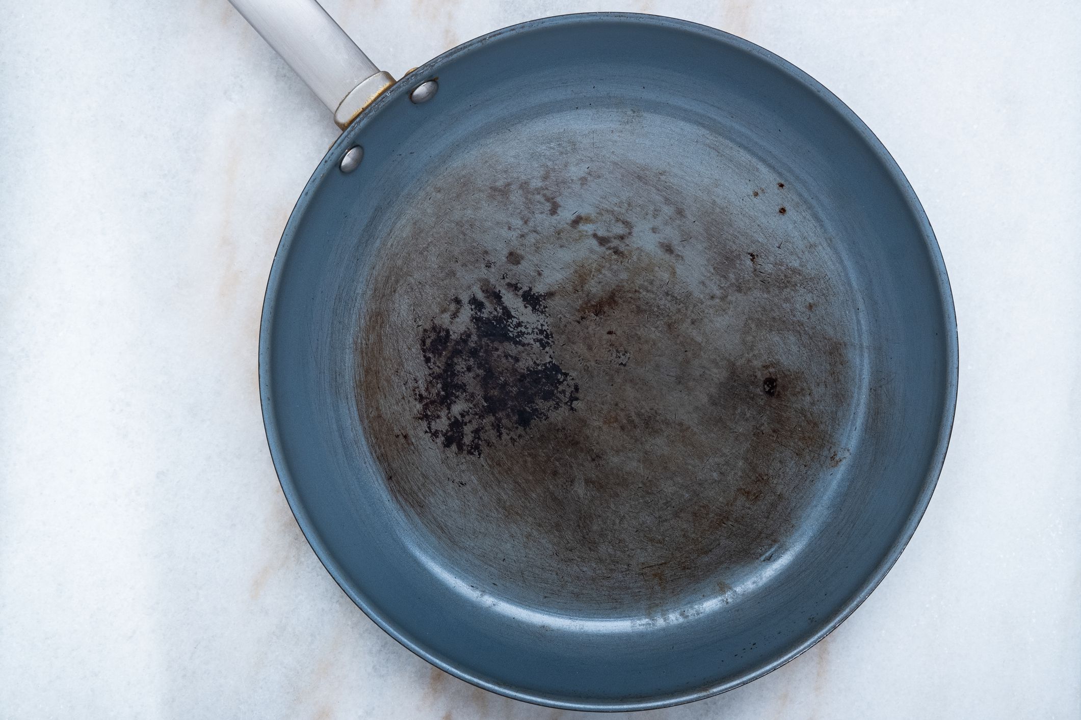 A soon to be discarded non-stick skillet with a damaged cooking surface