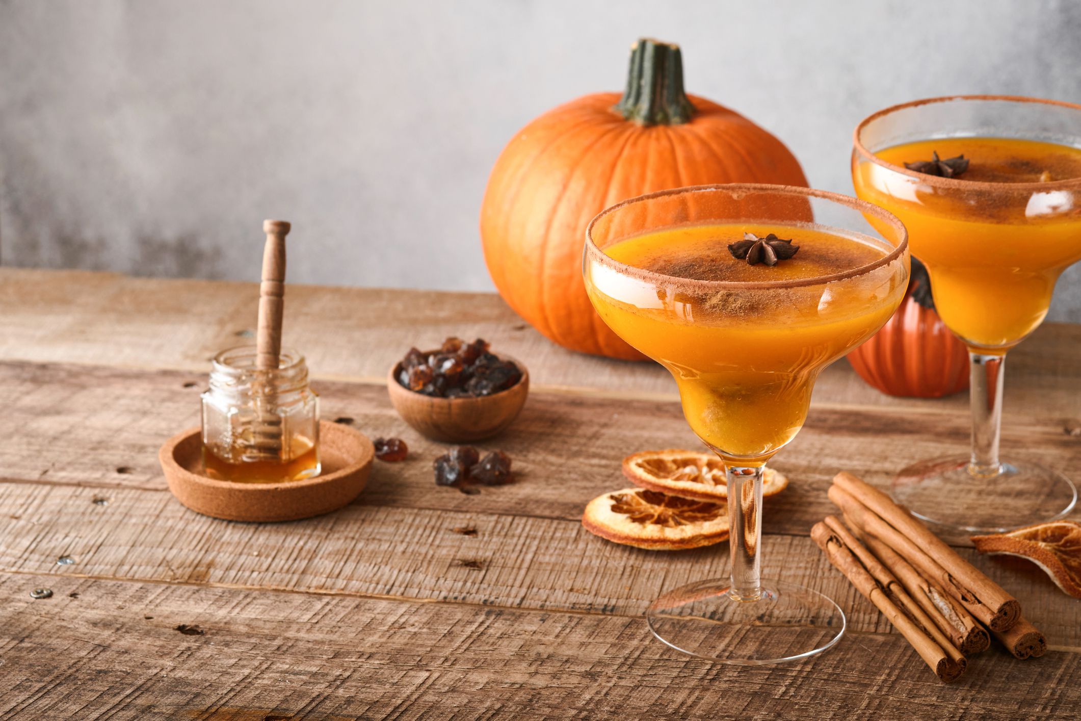 Pumpkin cocktail with cinnamon, orange juice and cocoa in glass mugs. Festive cocktail Halloween margarita. Pumpkin autumn drink for Halloween or Thanksgiving.