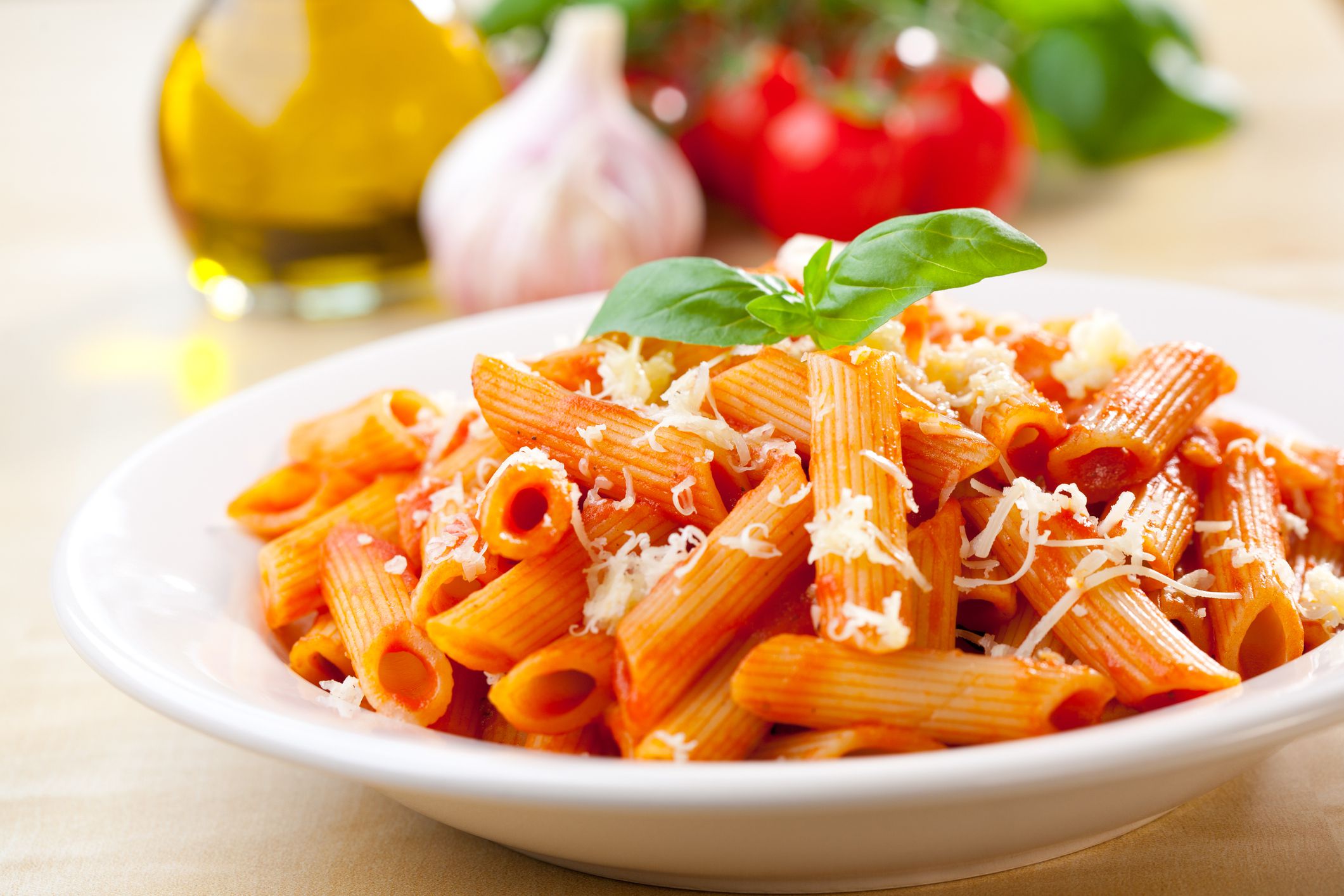 Plate of penne with ingredients in the background.
