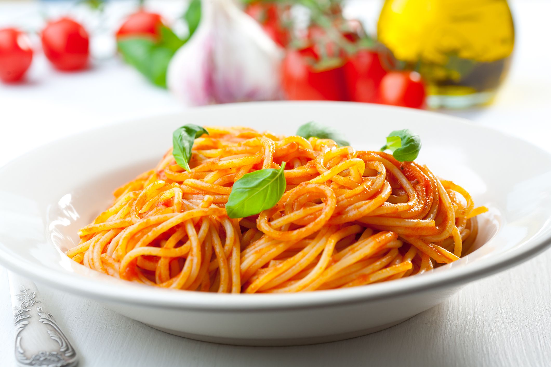 Plate of penne with ingredients in the background.