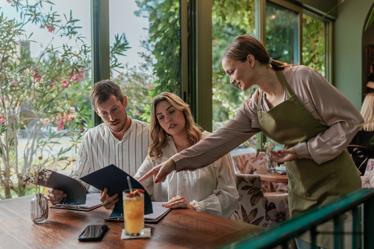 Waitress pointing at menu to make recommendations