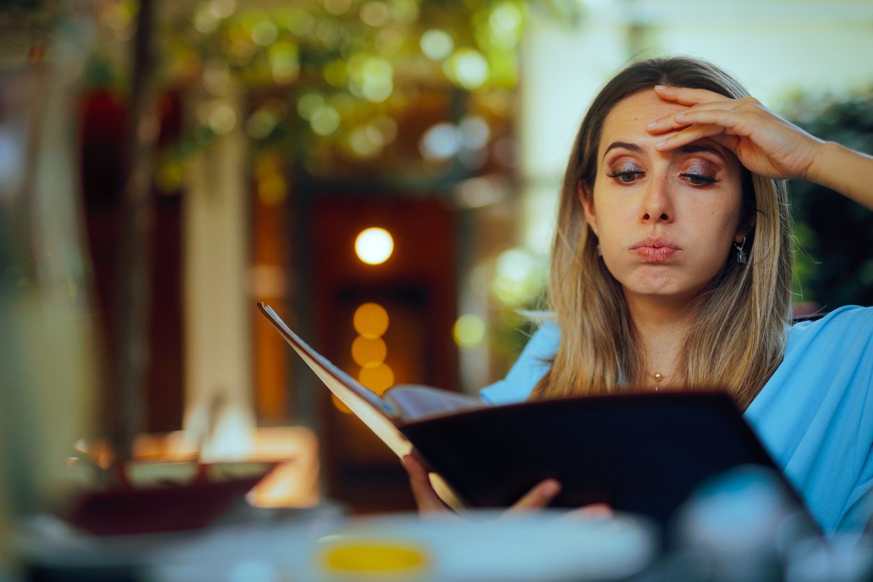 Woman looking overwhelmed by menu at restaurant