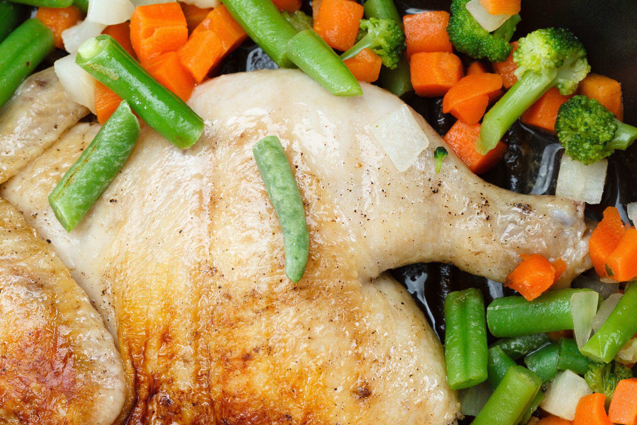 Whole grilled chicken with vegetables, cooked in a frying pan