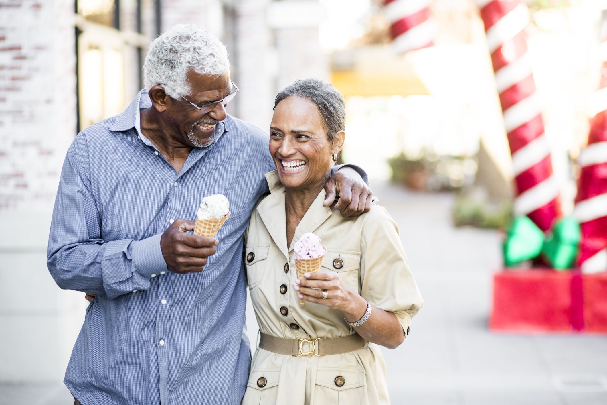 `A senior black couple eating ice cream on the town at Christmastime.
