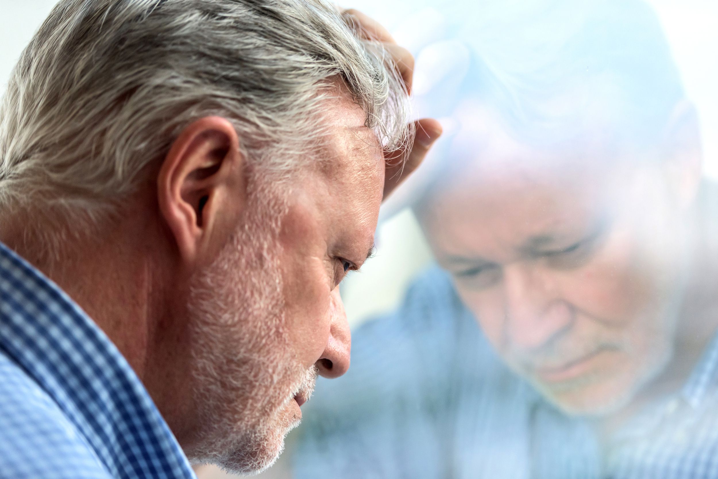 concerned senior man looking out of window