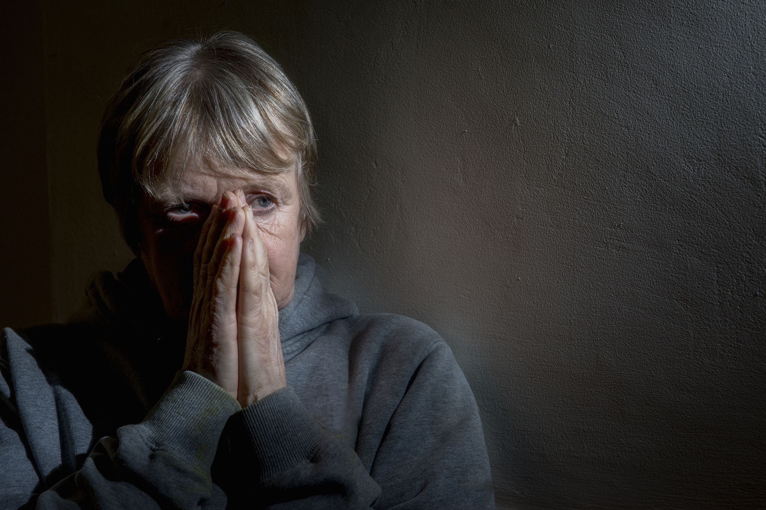 senior woman upset and worried in the darkness