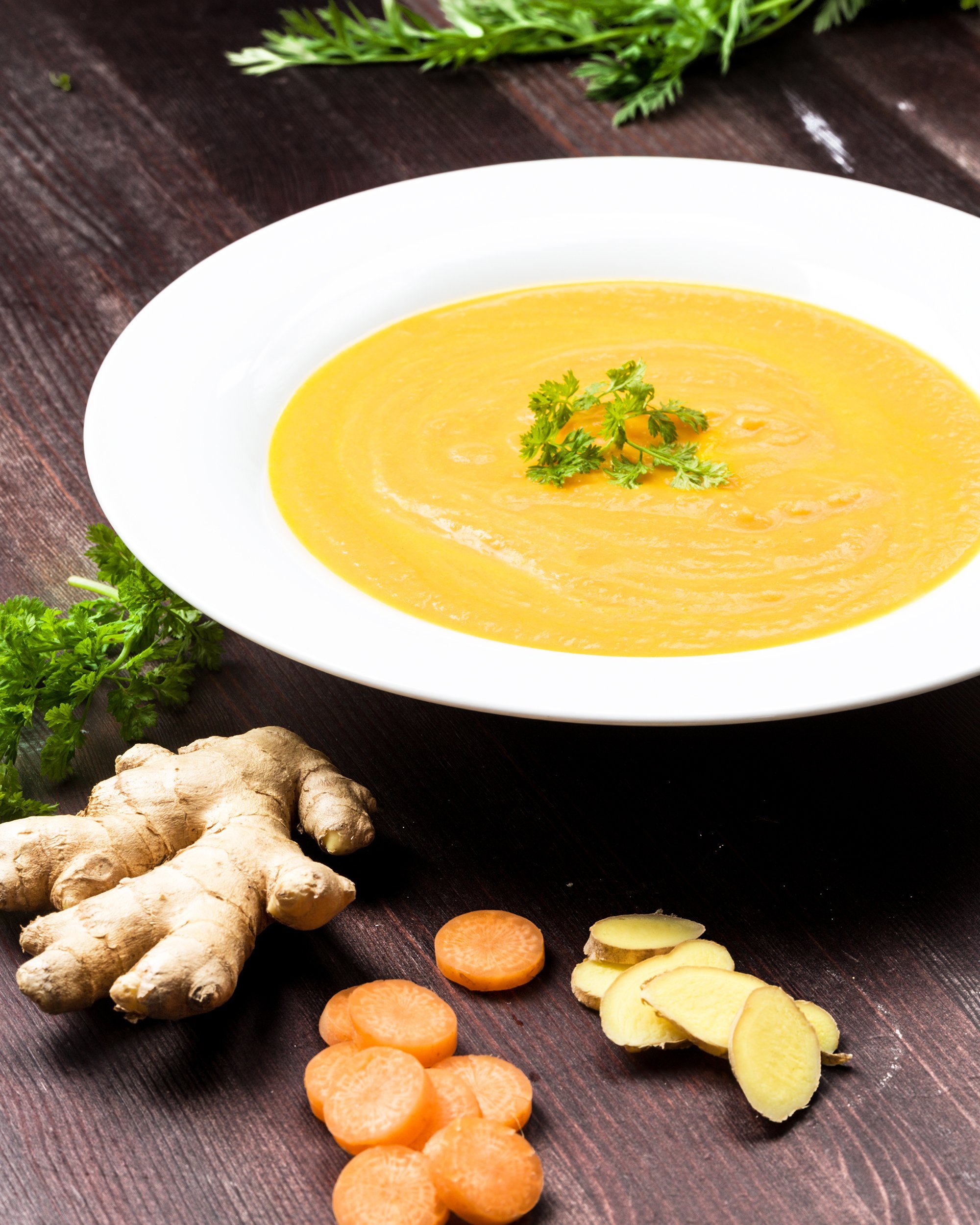 carrot ginger soup with ingredients on background