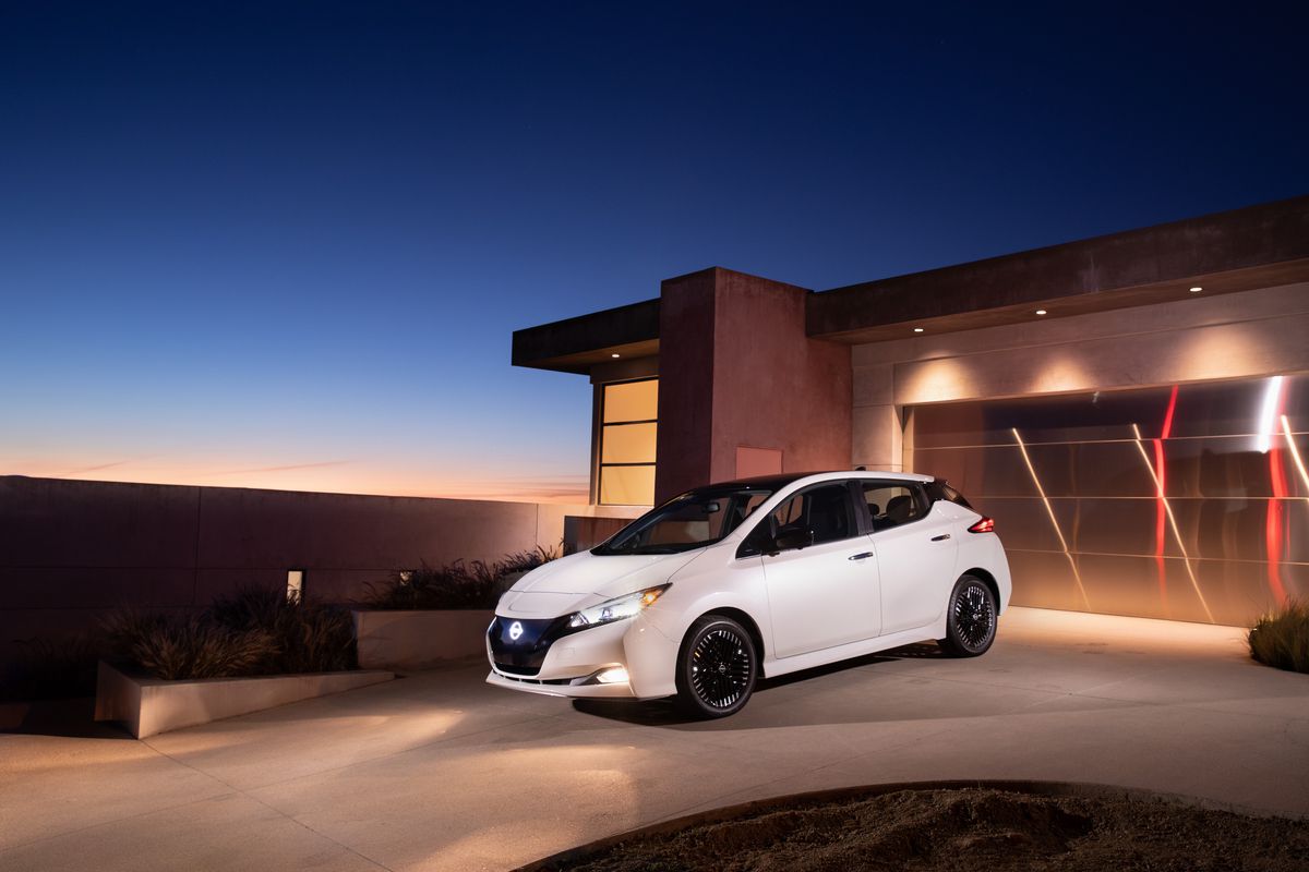 2024 white Nissan Leaf in front of house