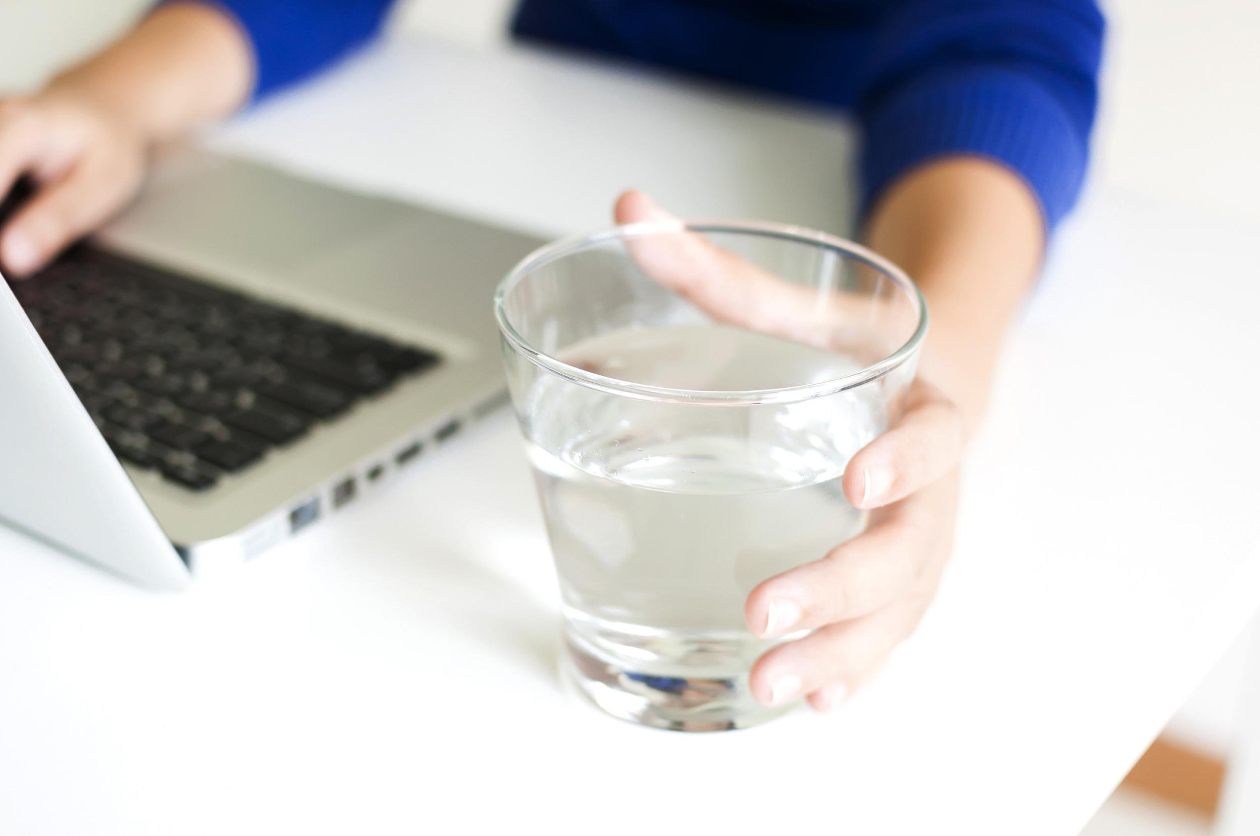 drinking water while working with laptop computer