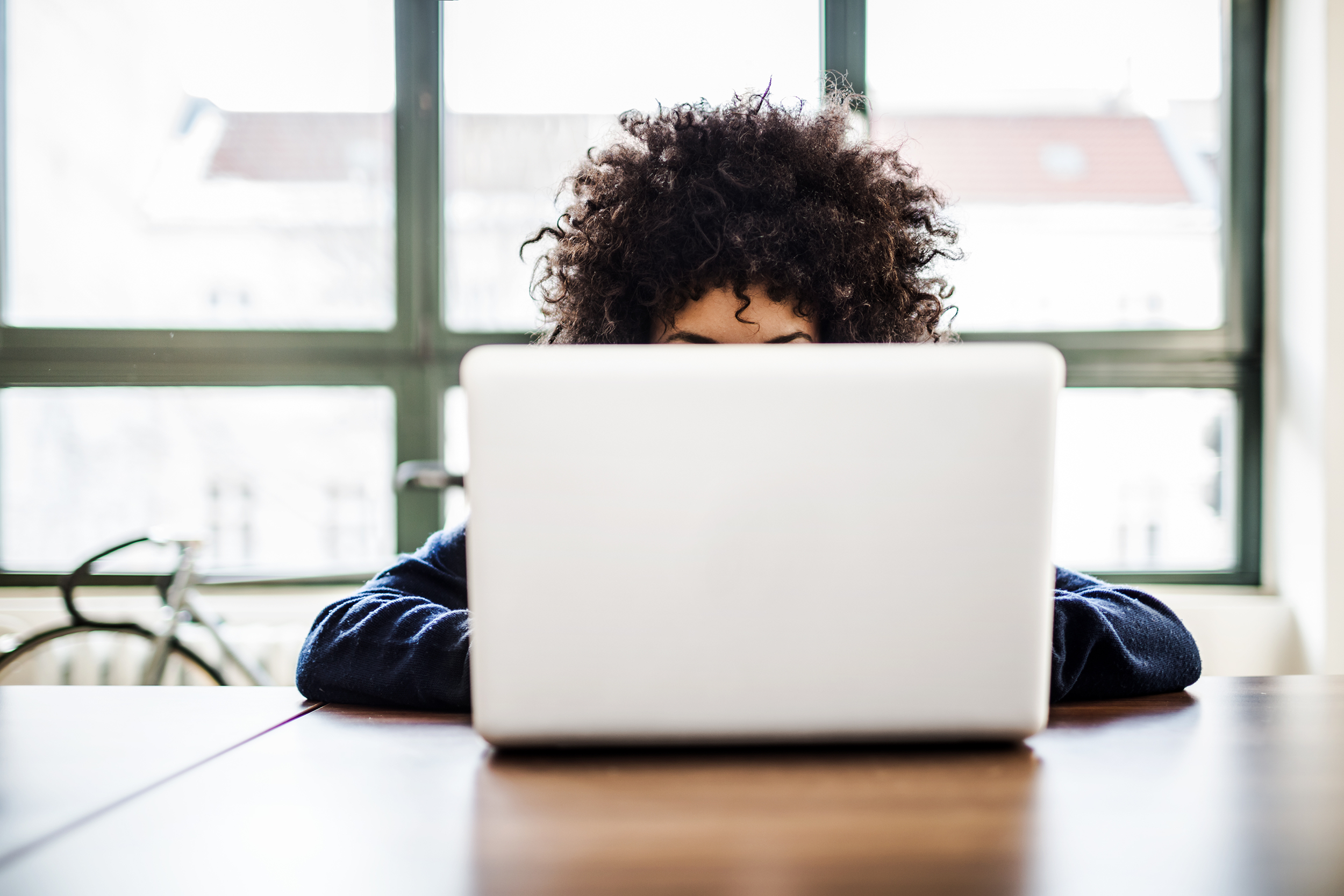 Hiding behind a laptop, focused on work