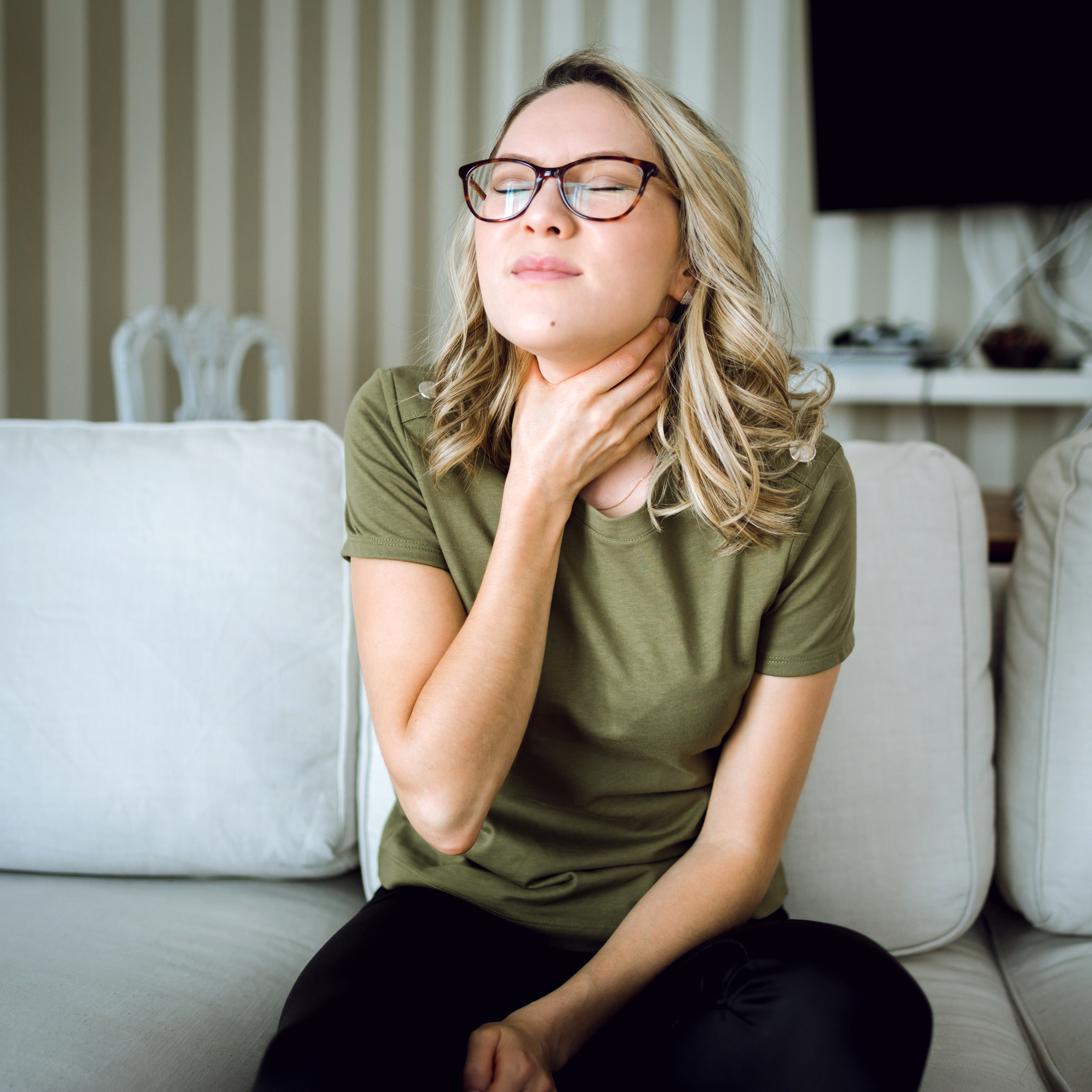 Woman holding her sore throat