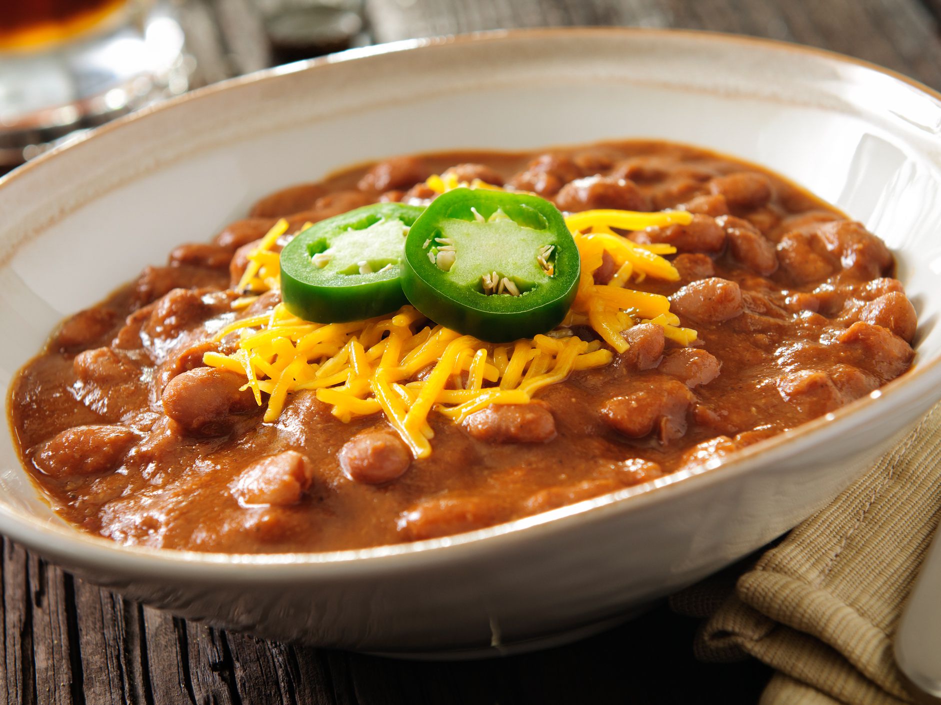 Bowl of chili with cheddar cheese and jalapeno and a beer. Please see my portfolio for other food and drink images.