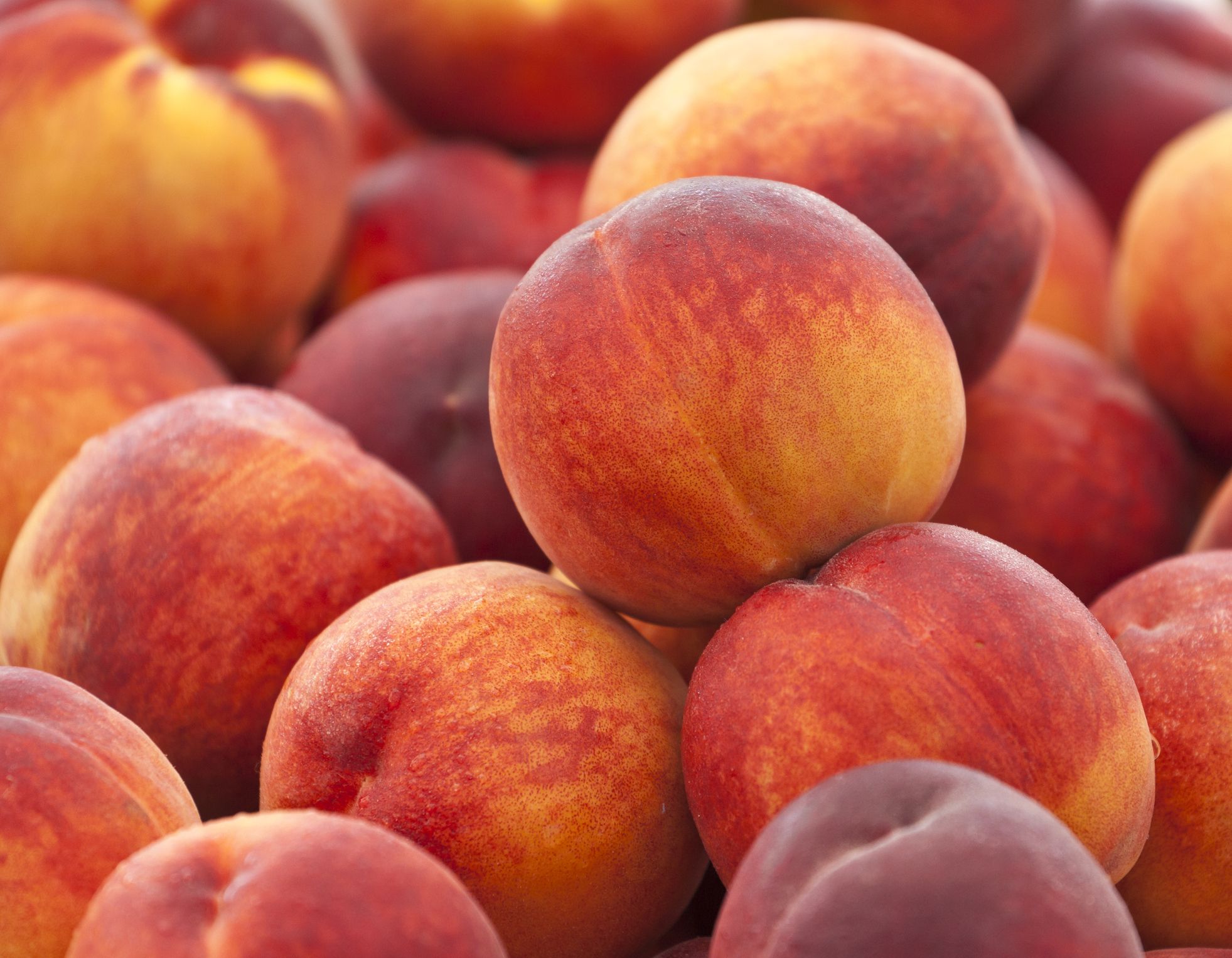 Heap of fresh organic peaches on display at a market.