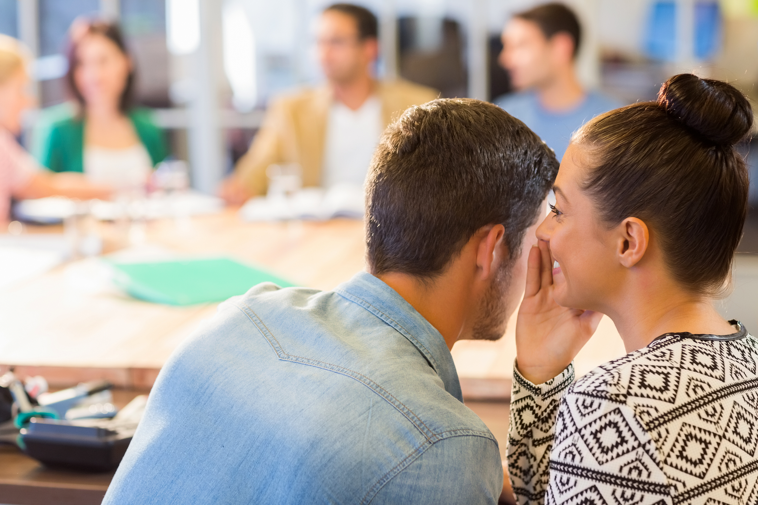 Coworkers gossiping during a meeting