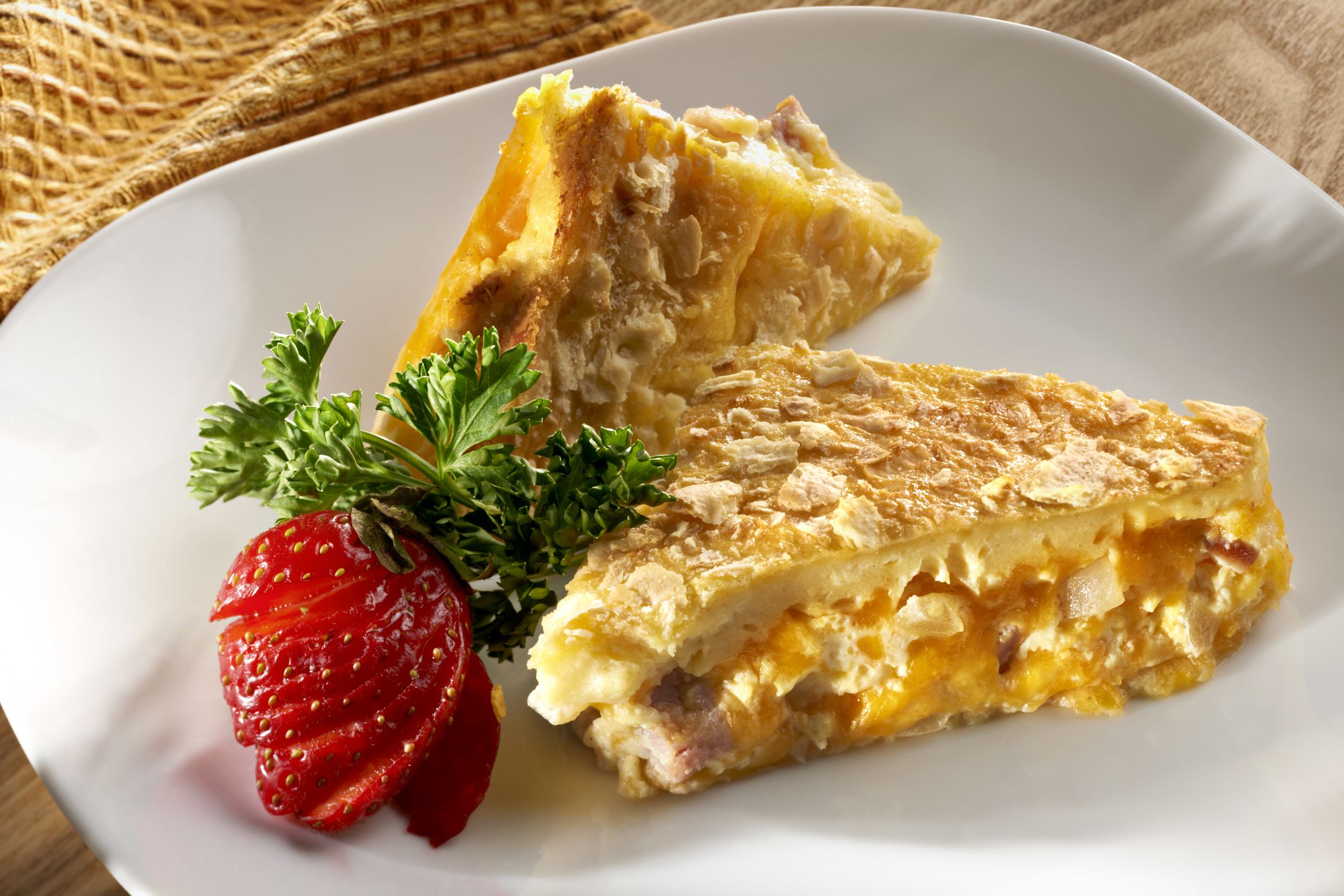 Eggs, ham, cheddar cheese and saute onion and saltines are layered and baked into a breakfast casserole.