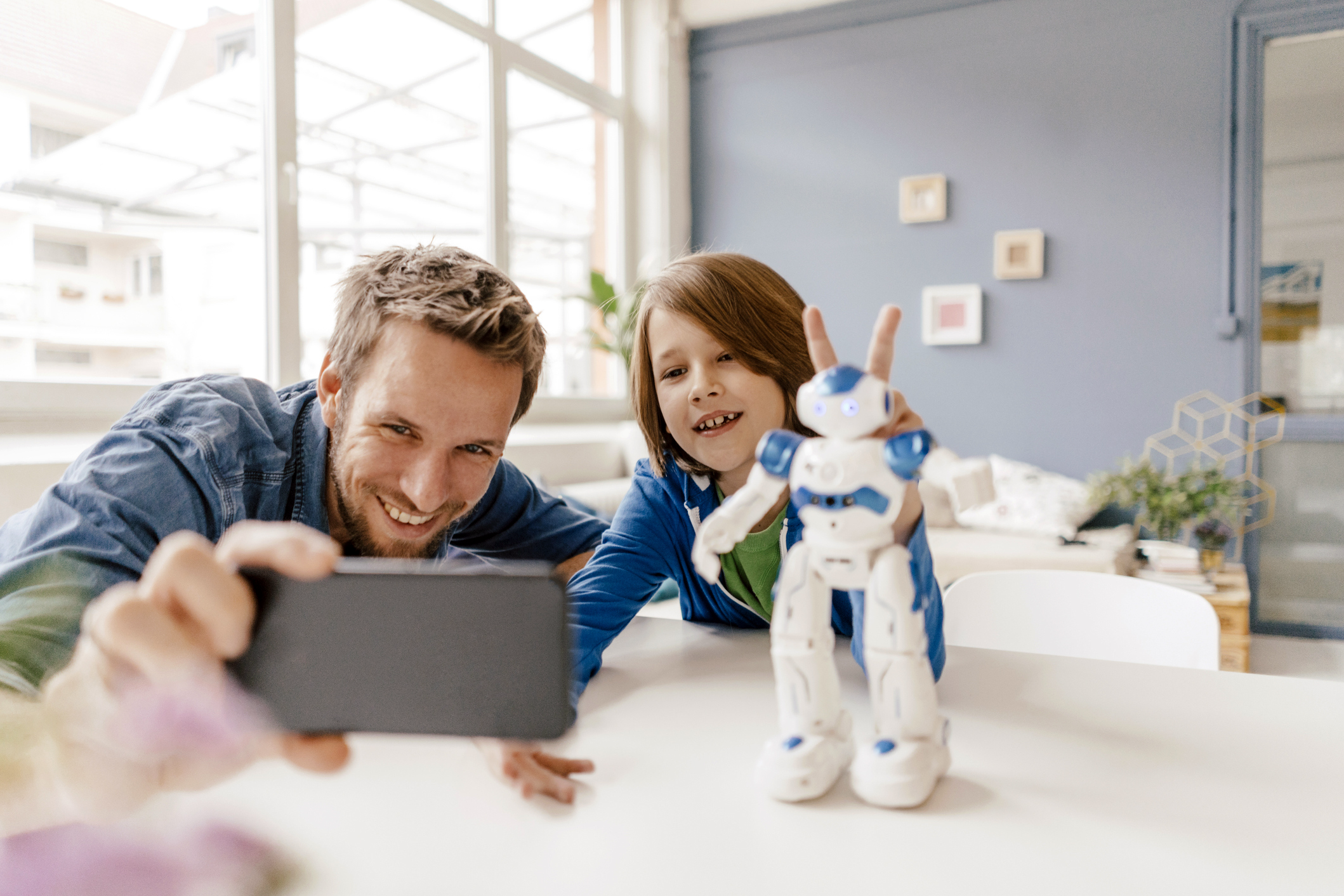 man and boy playing with toy taking selfie