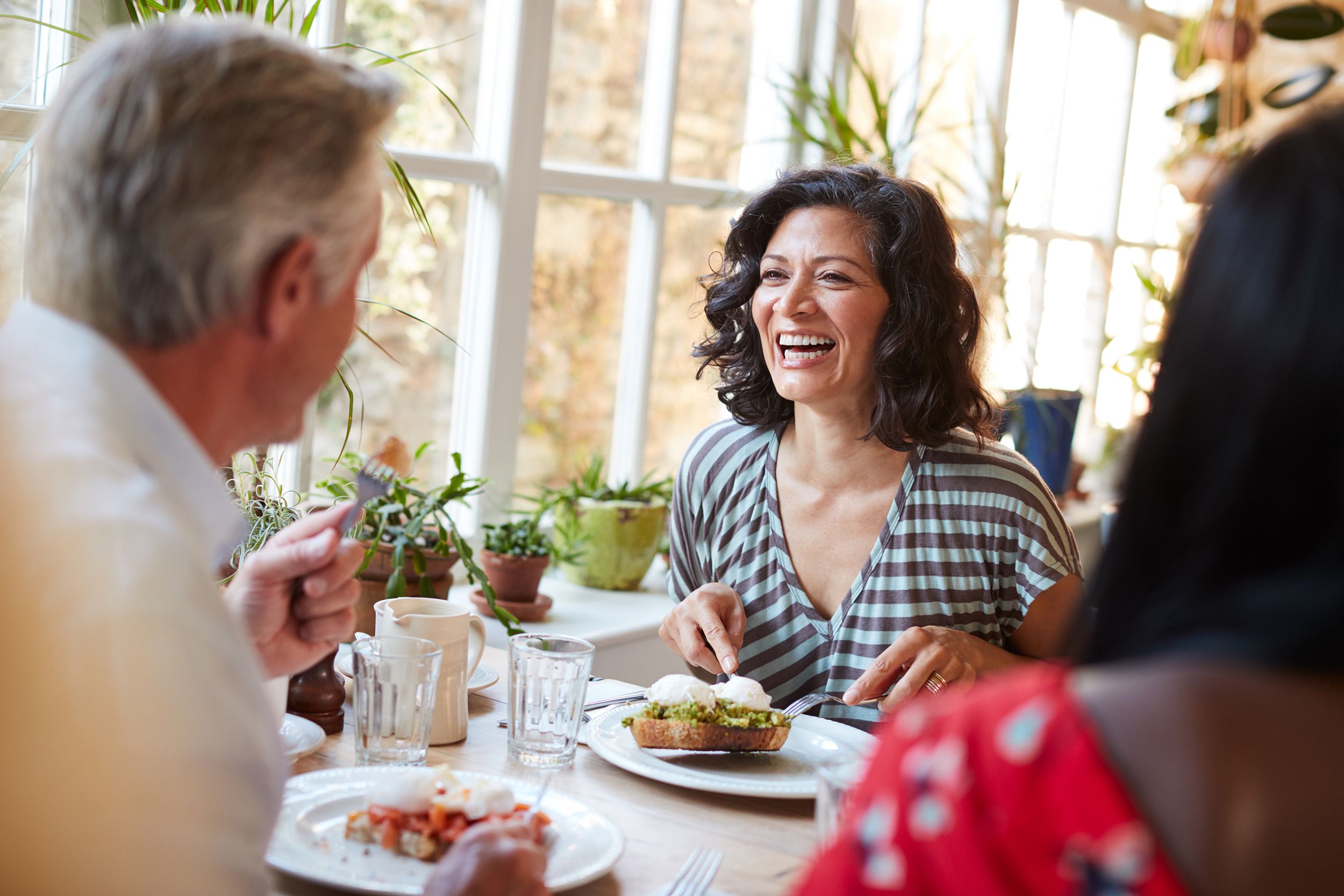 laughing woman laughing with male friend at a cafe