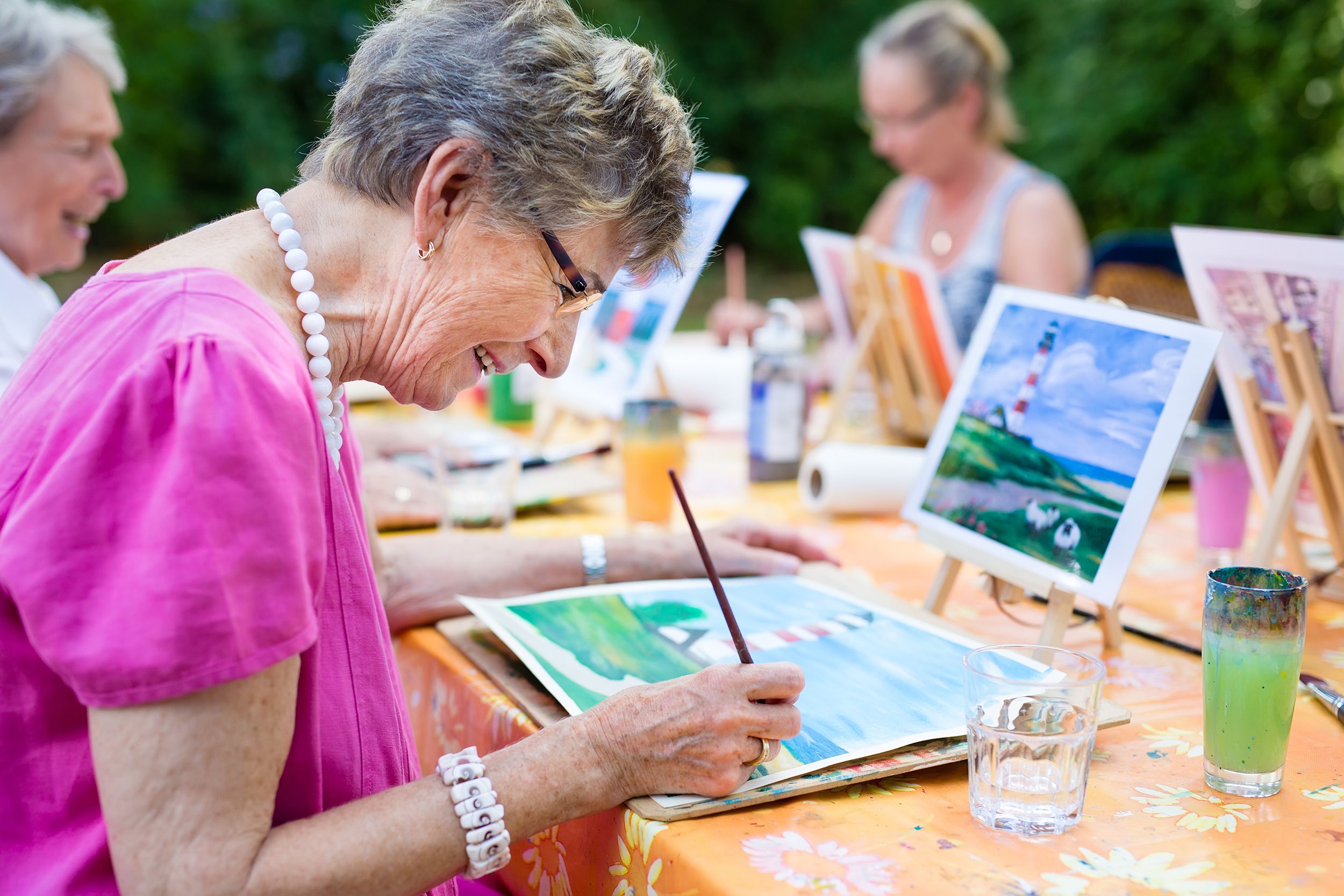 senior woman smiling while drawing with the group