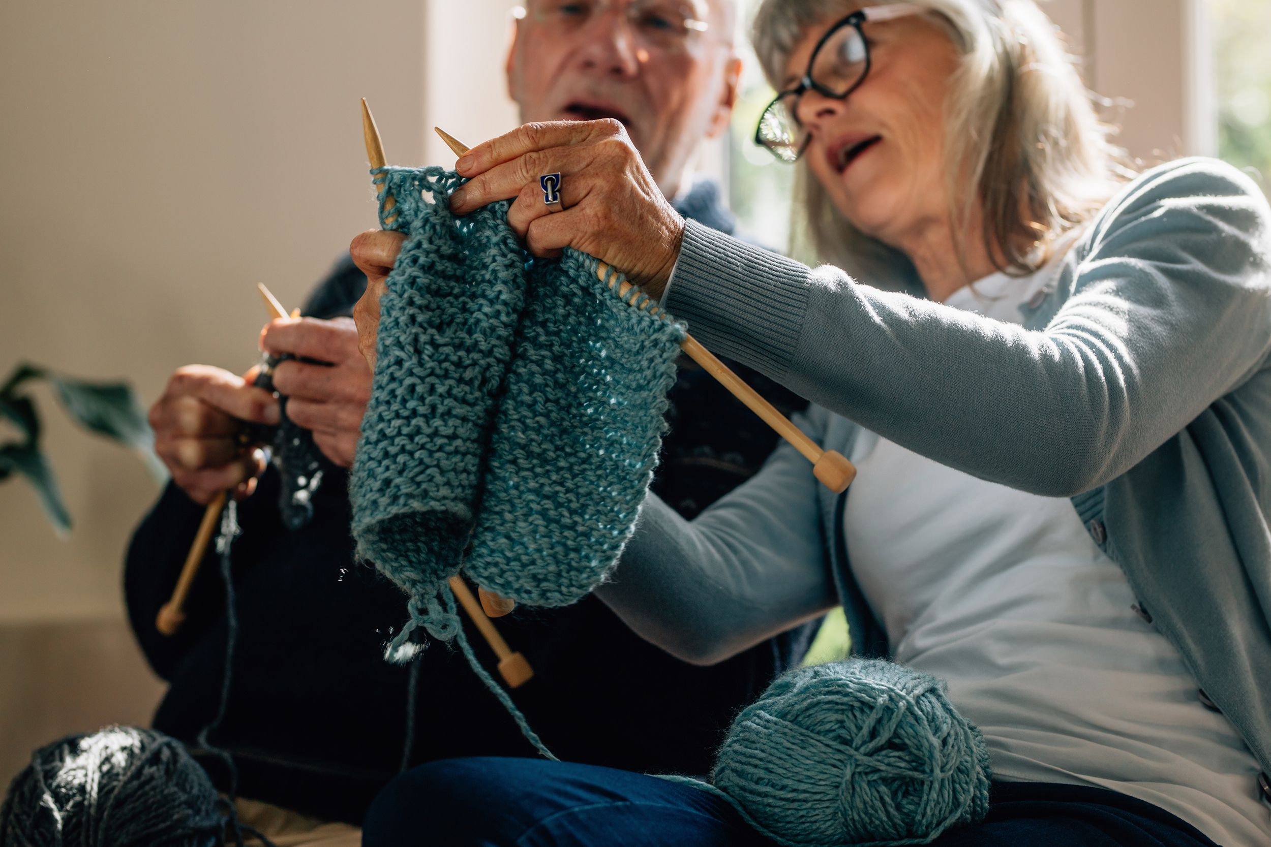senior couple knitting wool in class