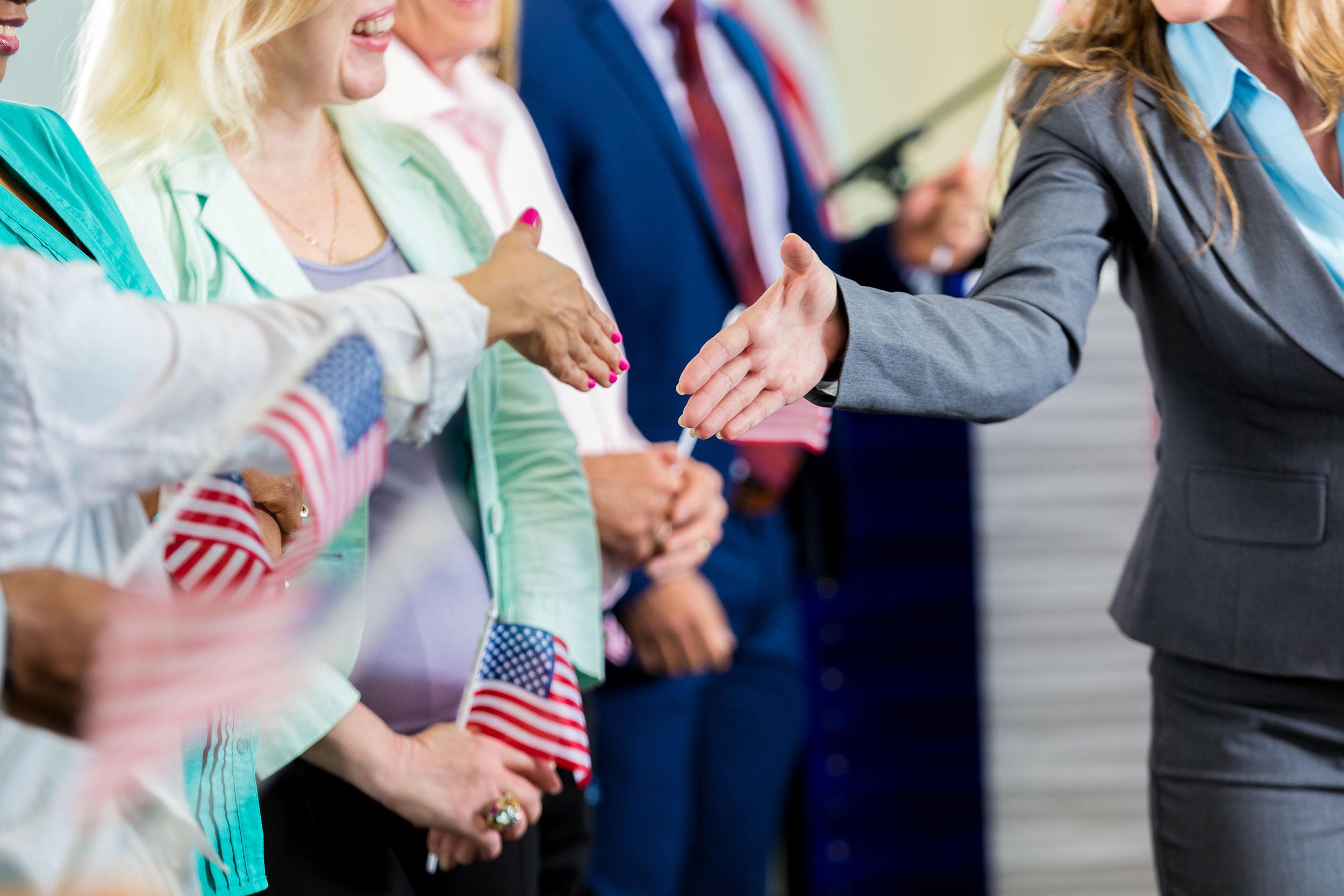 female politician shaking hands with supporters at event