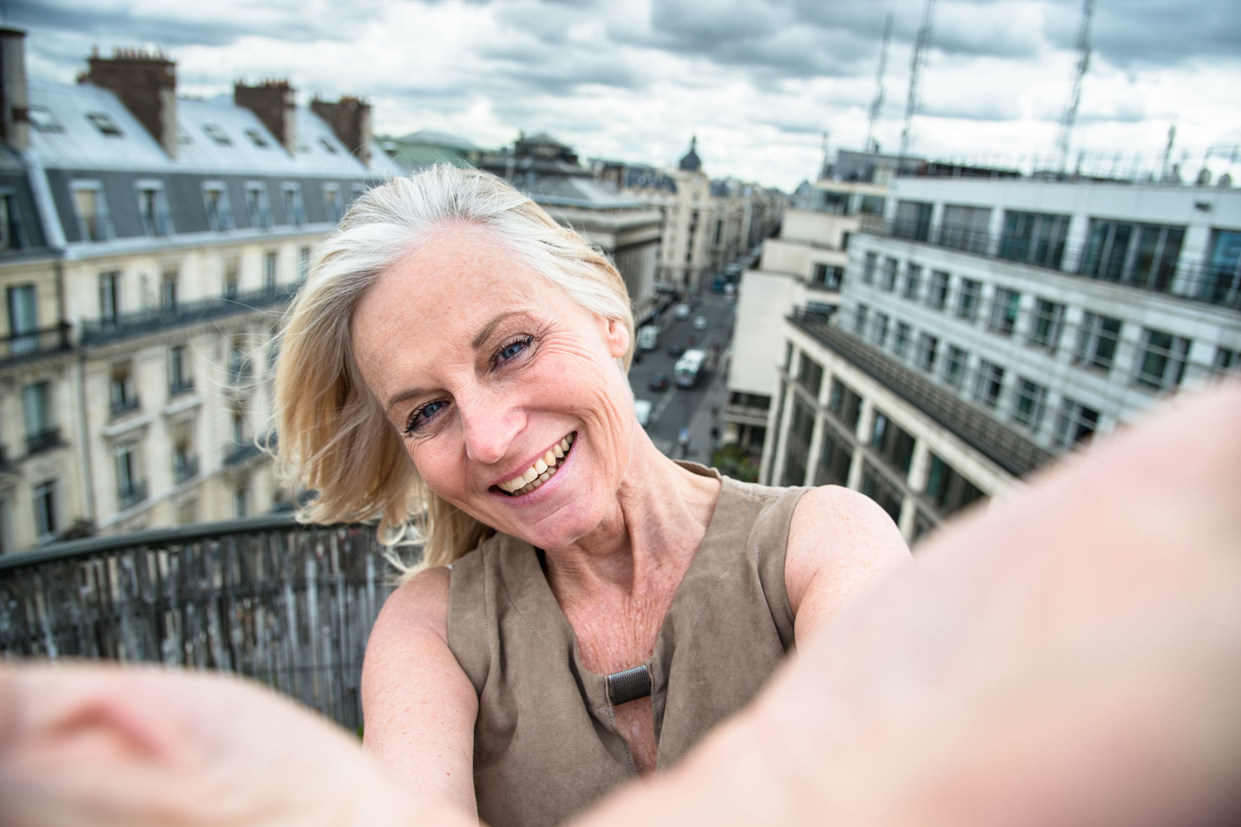 middle-aged woman take a selfie on the rooftop in Paris