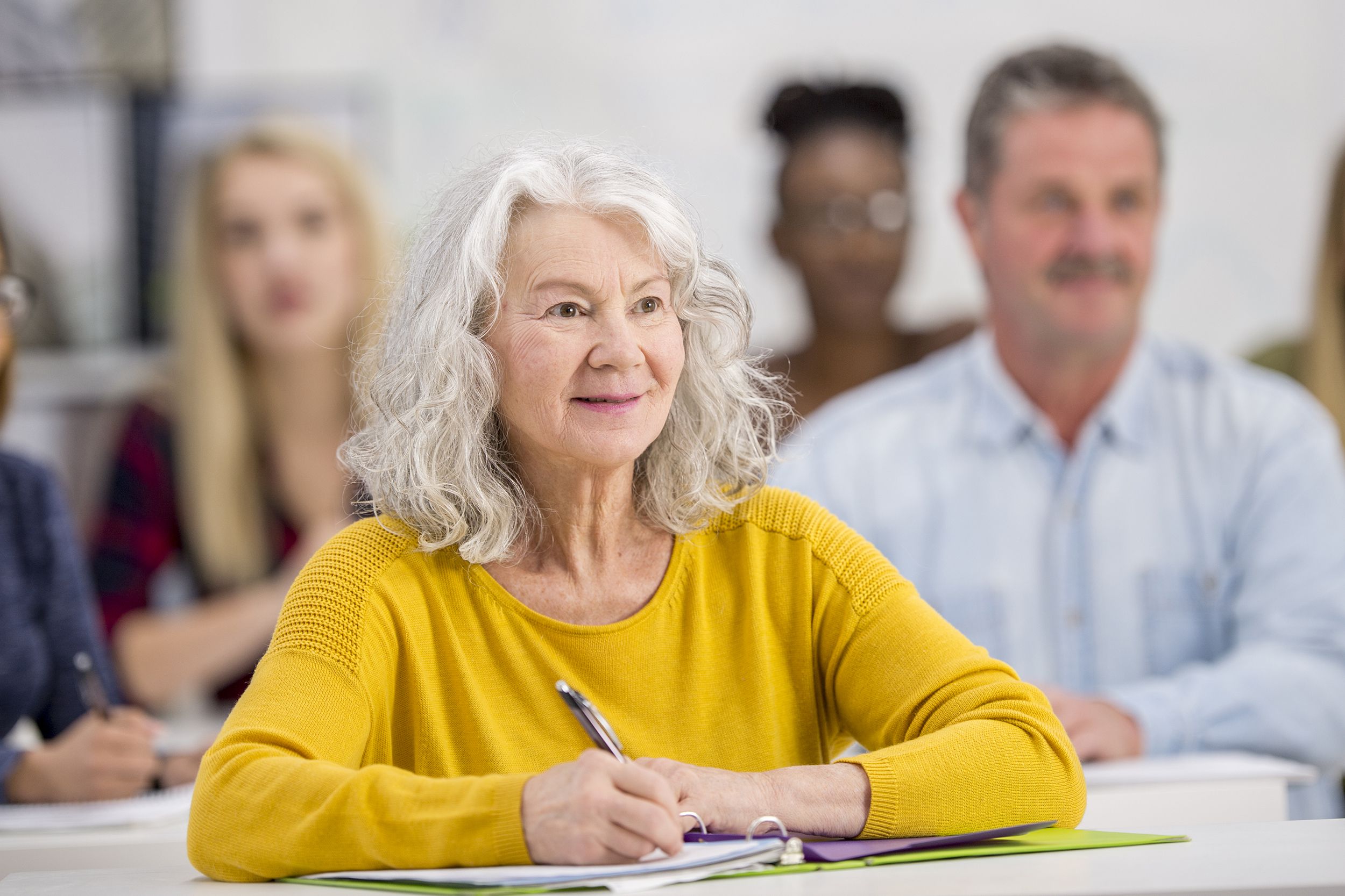 senior woman in college class with mixed age group of students