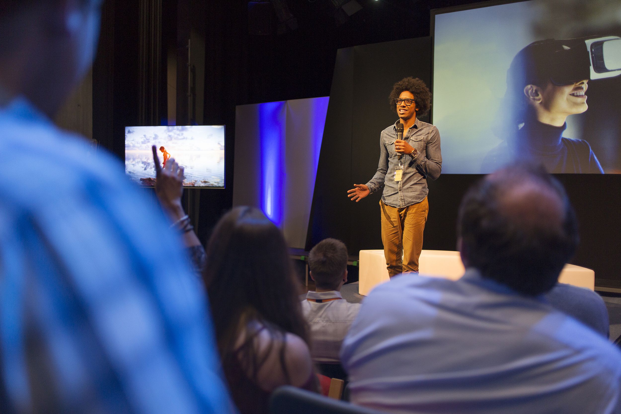 male speaker on stage talking to audience