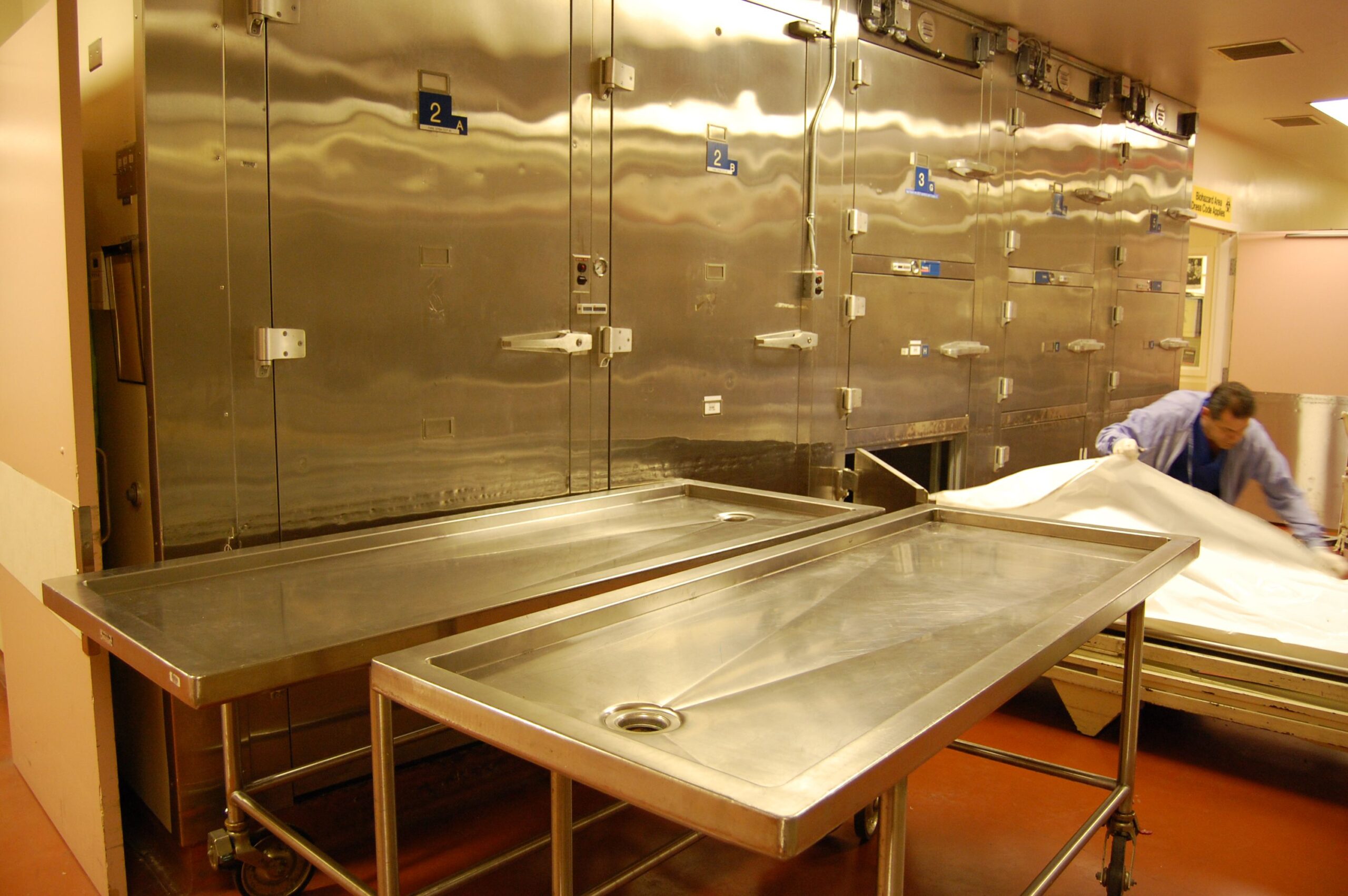 A pathology assistant examines a body stored in the cooler lockers. Bodies involved in police investigations are stored in these chambers, also known as crypts, since they can be locked.