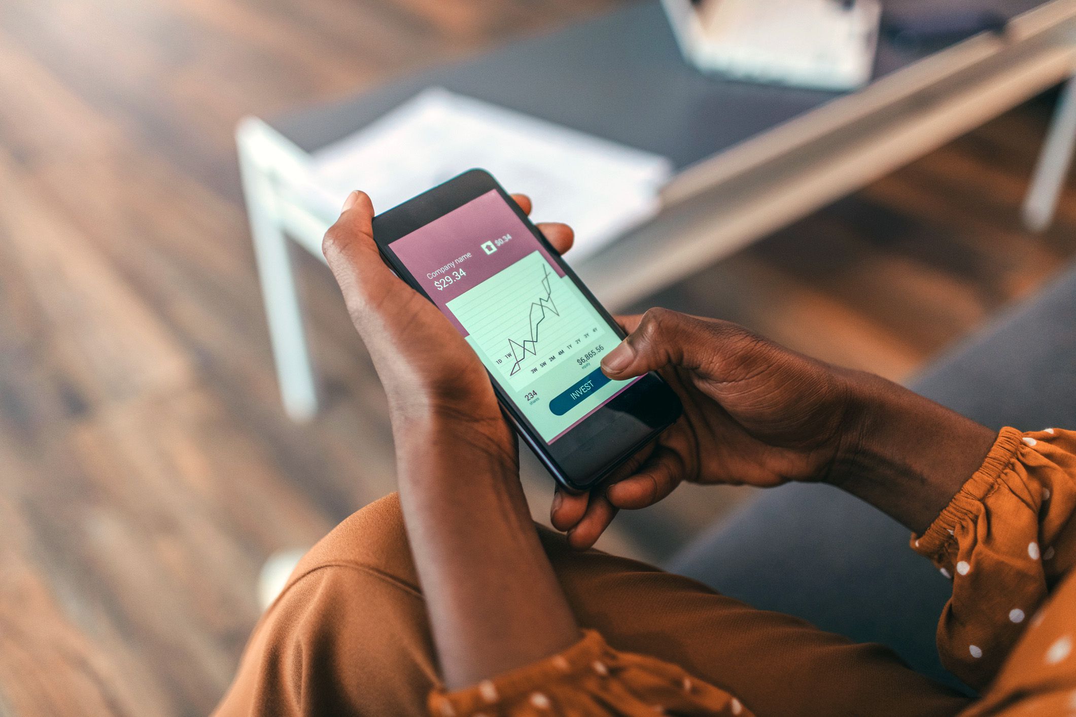 hands holding phone looking at stocks