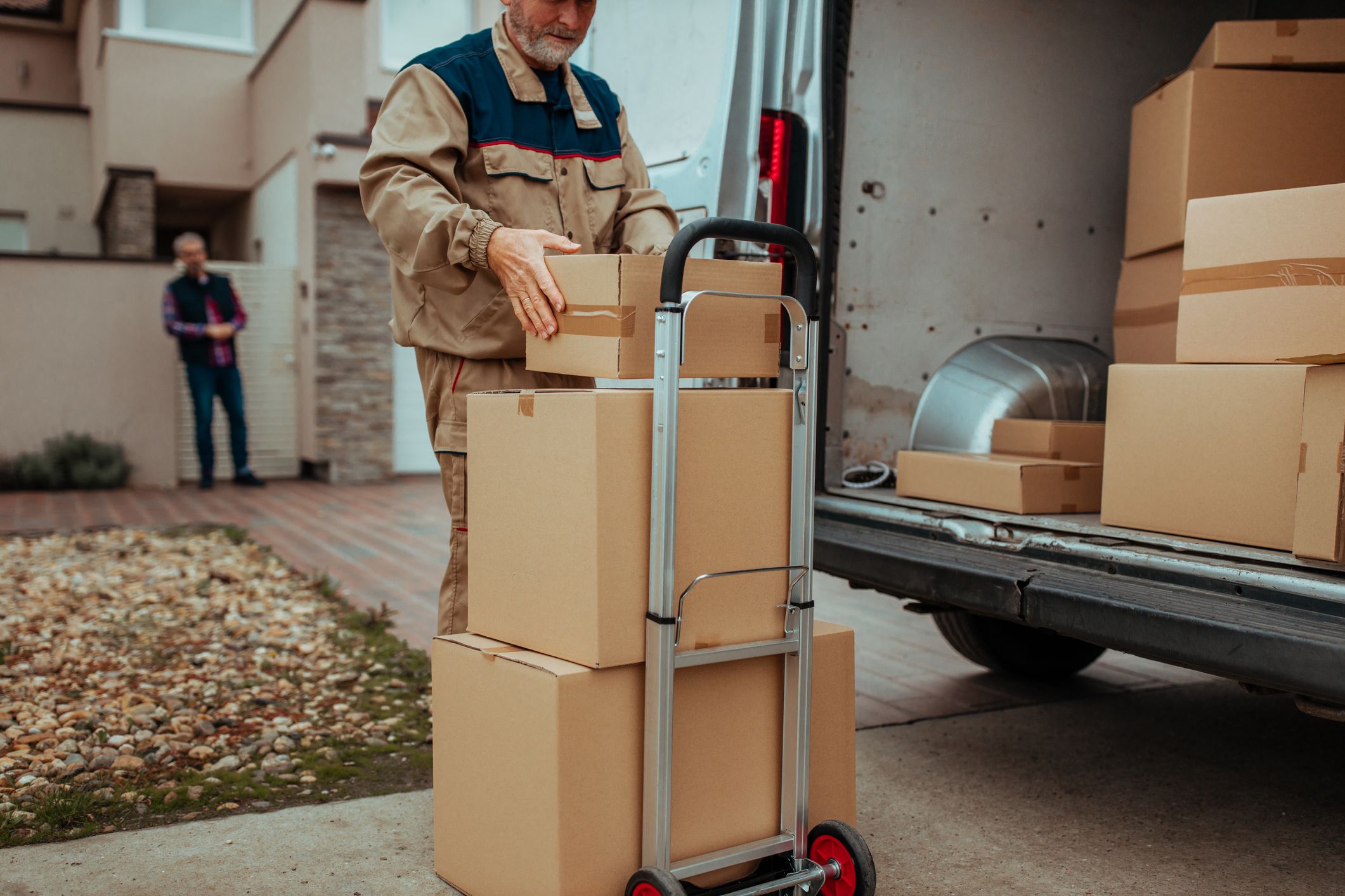 Delivery man putting an order to the cart to deliver them to the client.