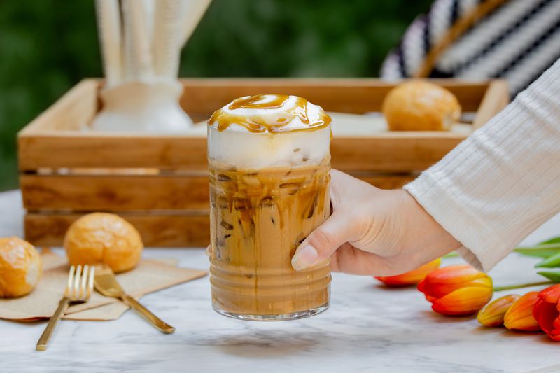 Hand Holding caramel iced coffee