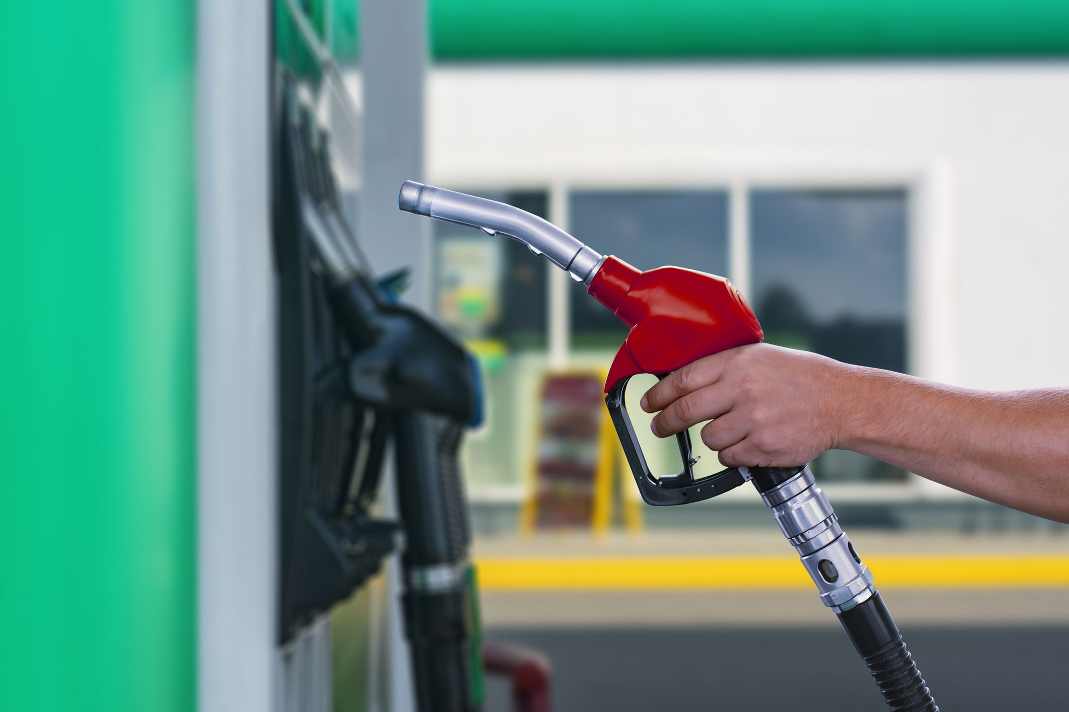 Man holds a refueling gun in his hand for refueling cars. Gas station with diesel and gasoline fuel close-up