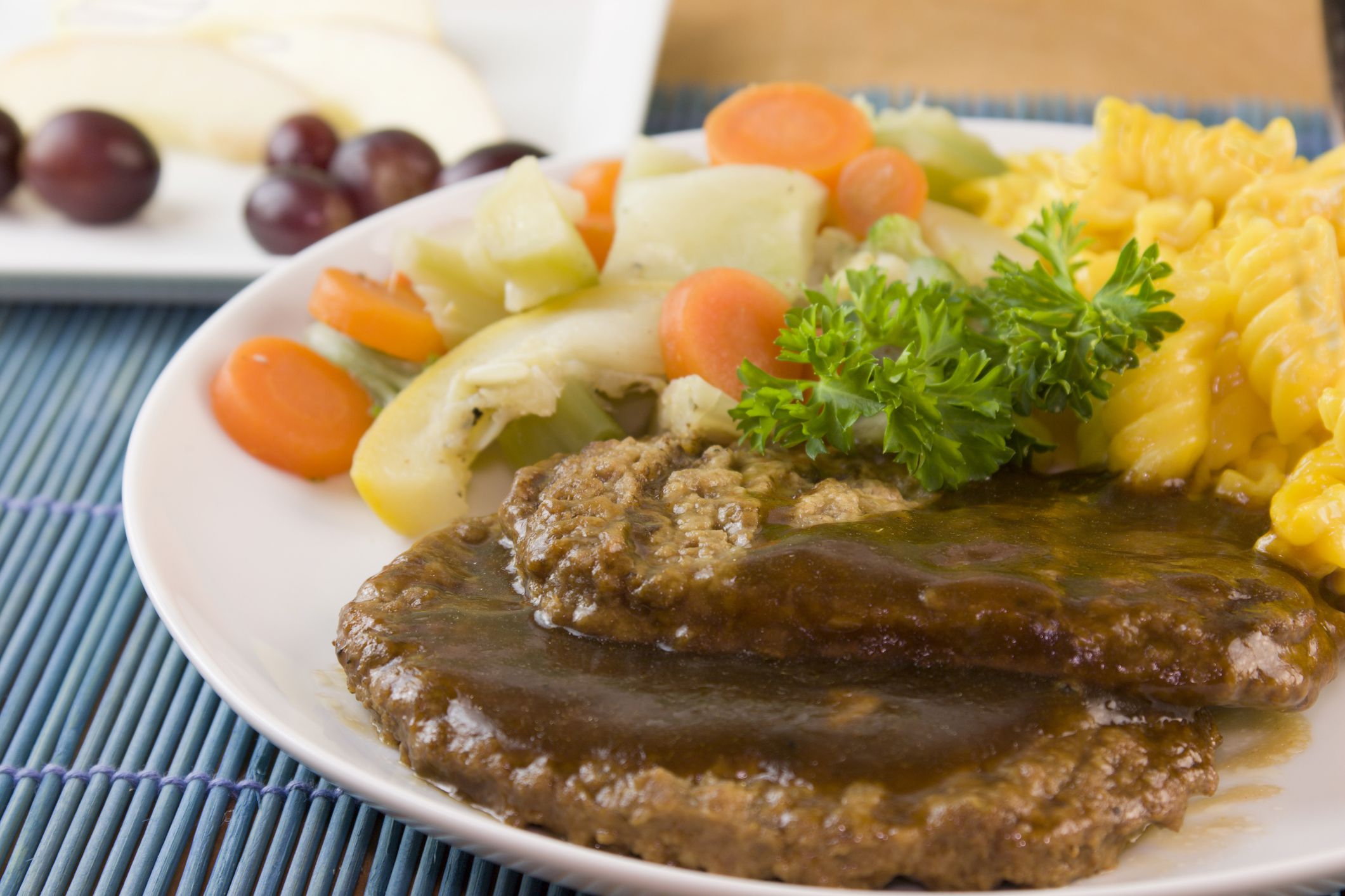 detail of salisbury steak patties with steam vegetables and spiral macaroni