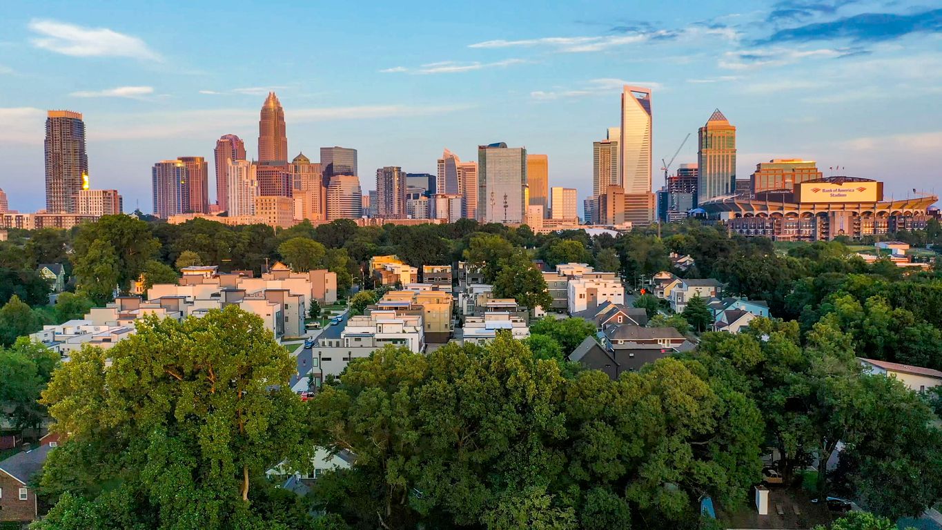 An image of Charlotte, North Carolina on a blue sky sunny day with trees showing.