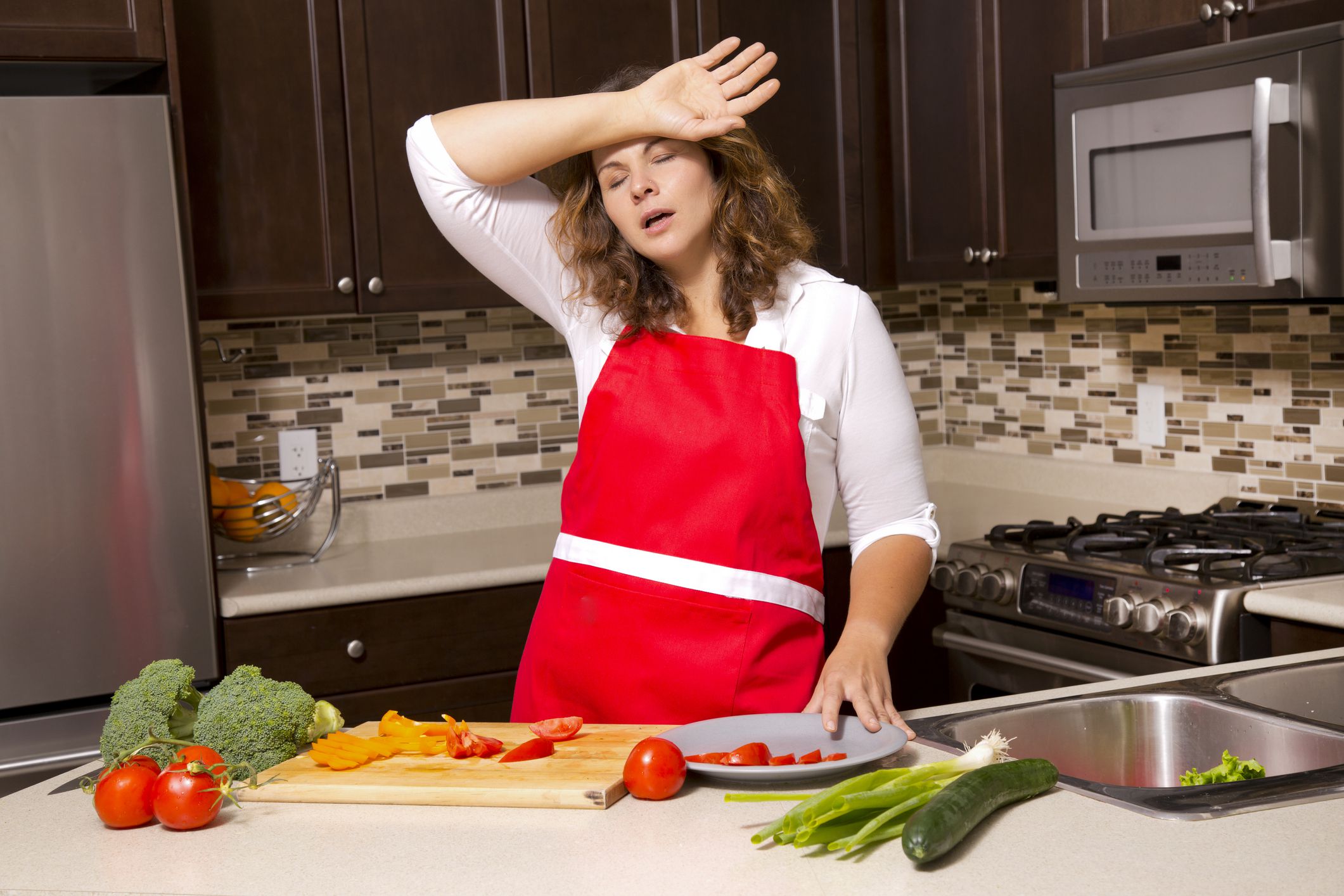 woman cooking with raw vegetables in the kitchen