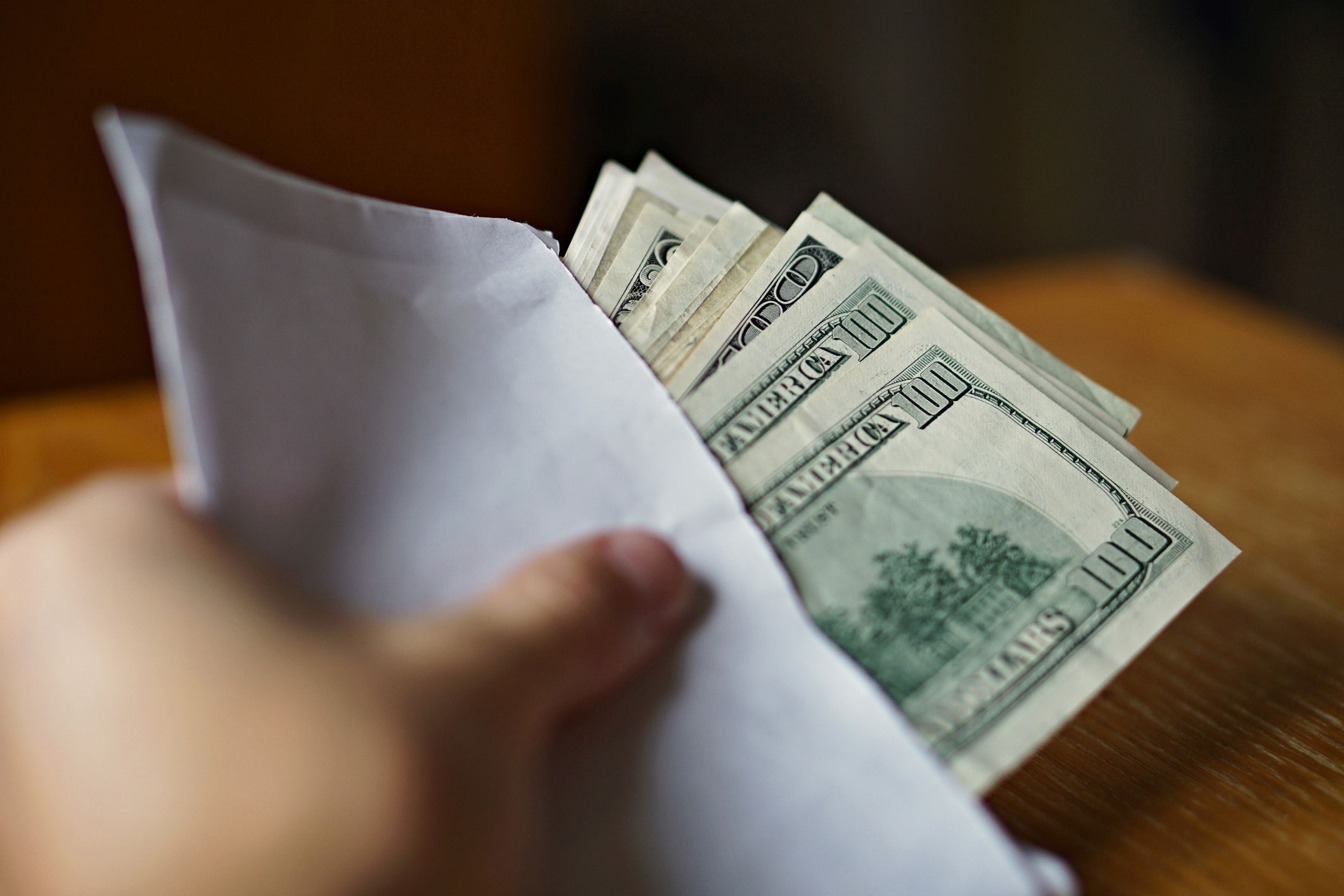 hand with envelope full of cash