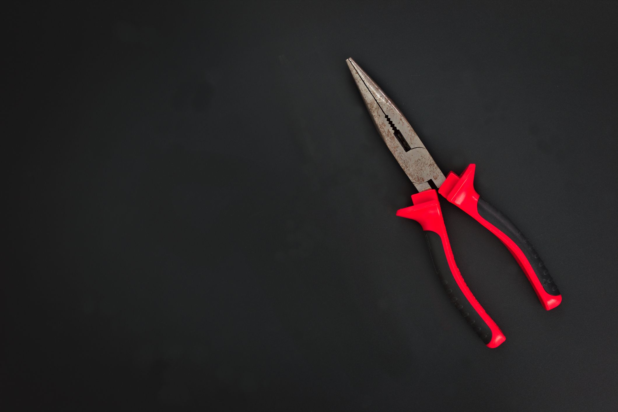 Must have at home used hand tools Needle Nose Pliers on black background with copy space