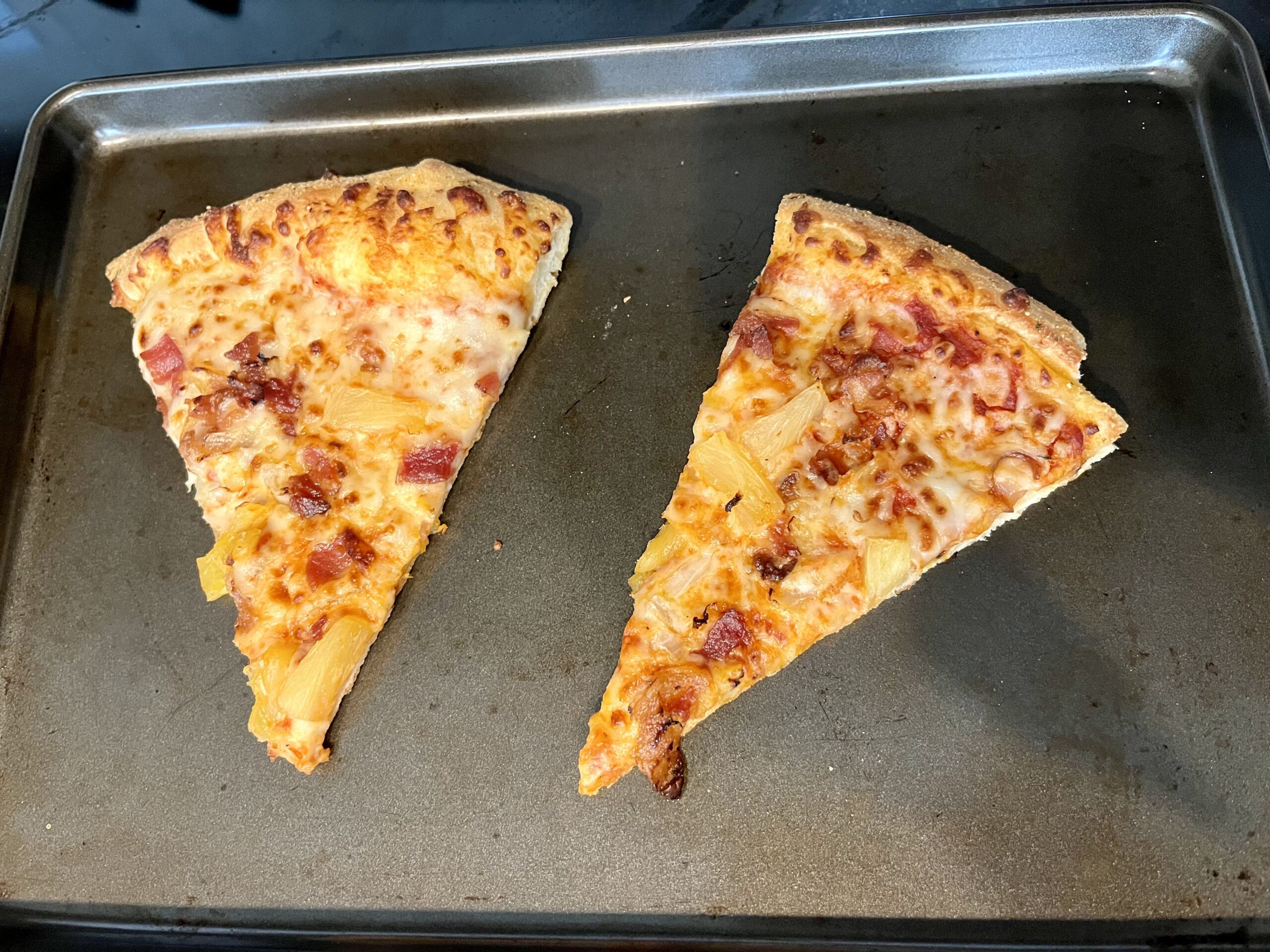 two slices of pizza reheated in the oven