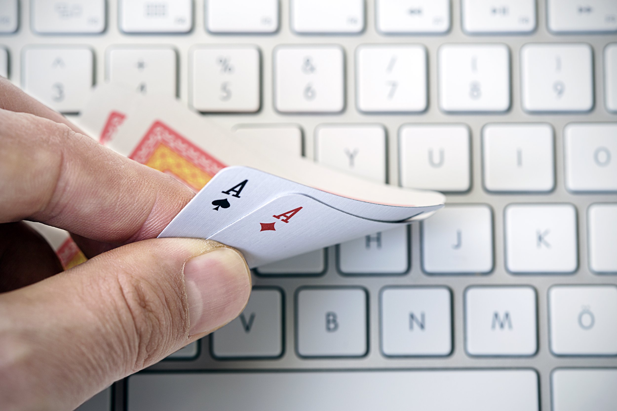 hand holding two aces on keyboard