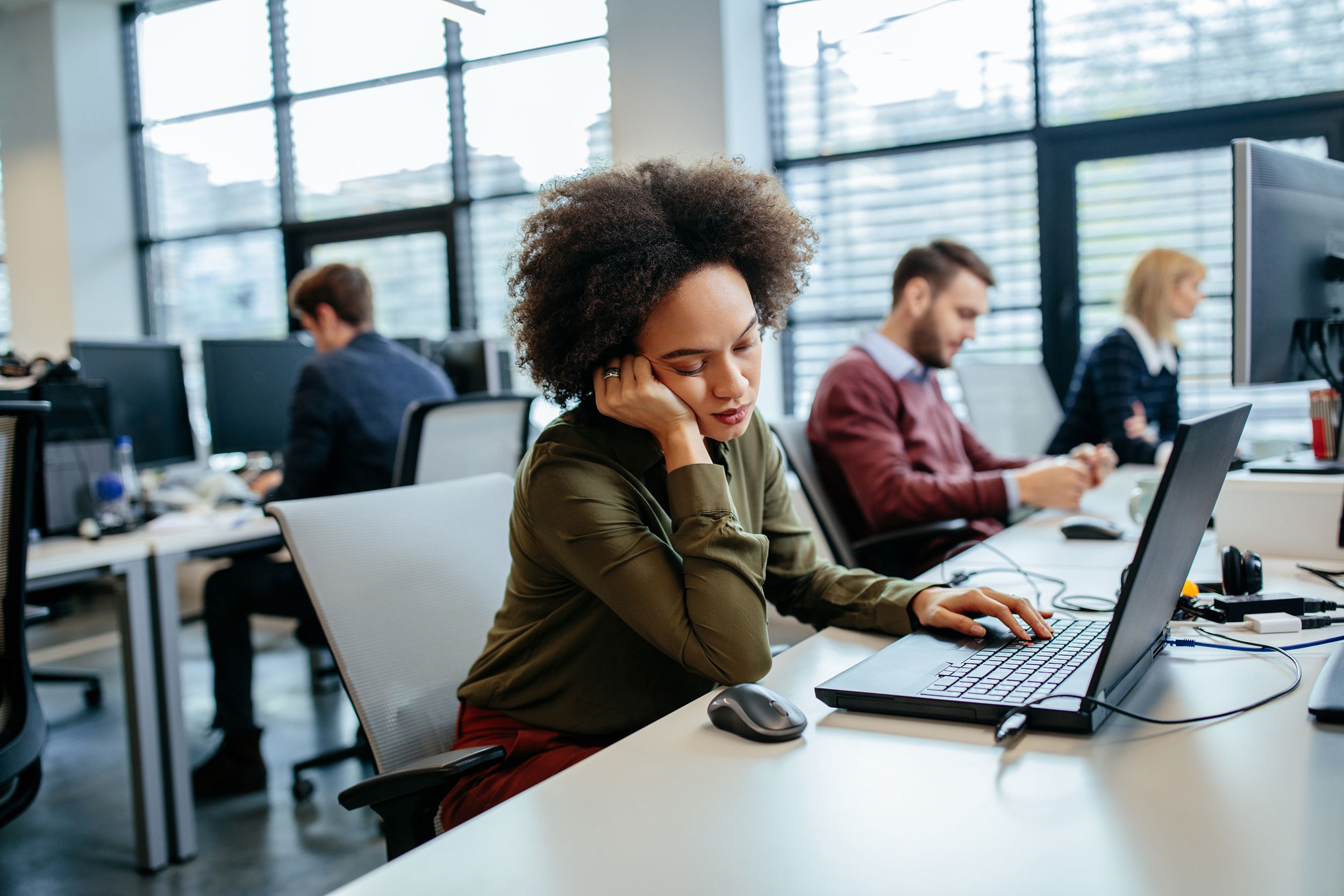woman falling asleep at work in front of desk