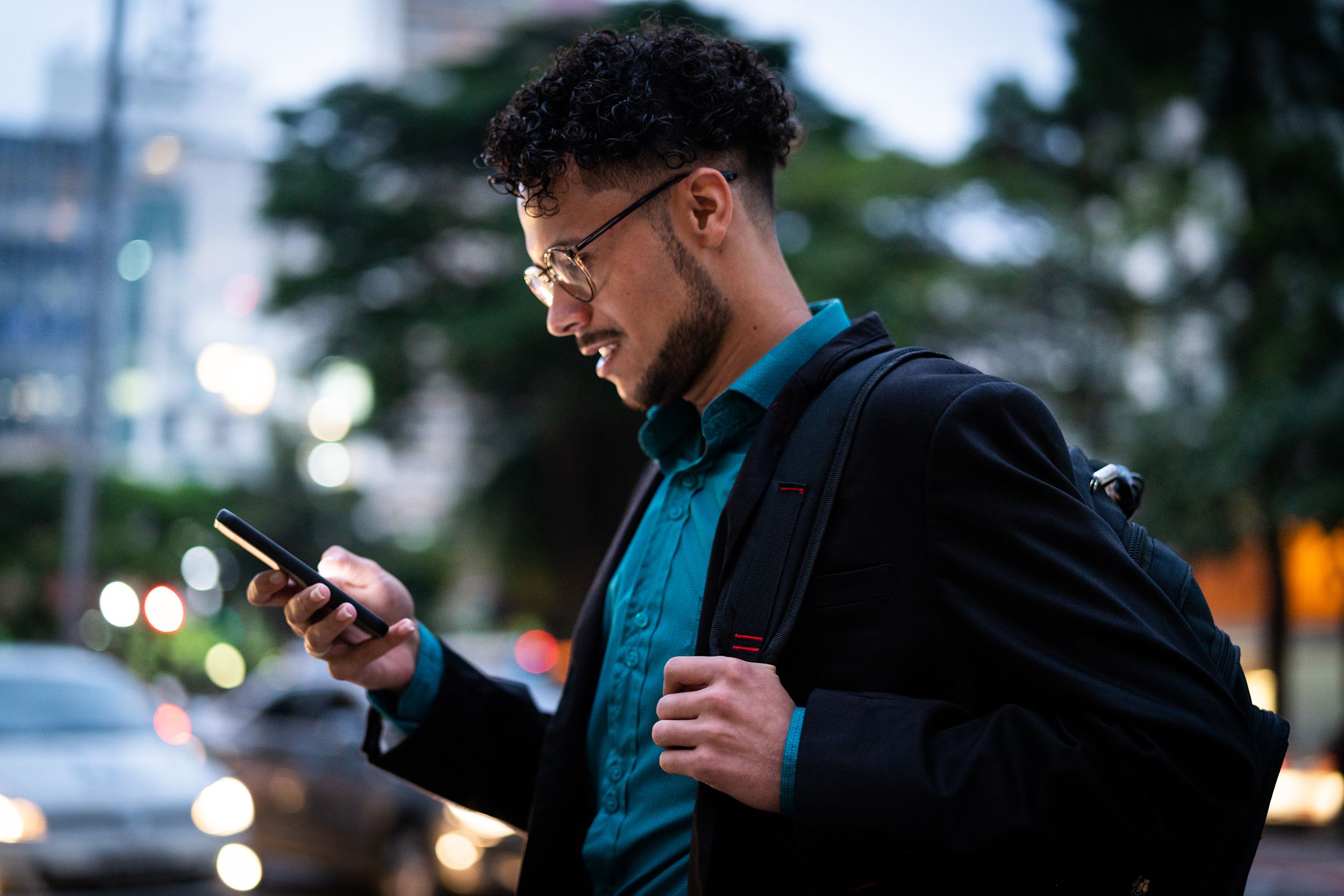 man on phone while walking outside in early evening