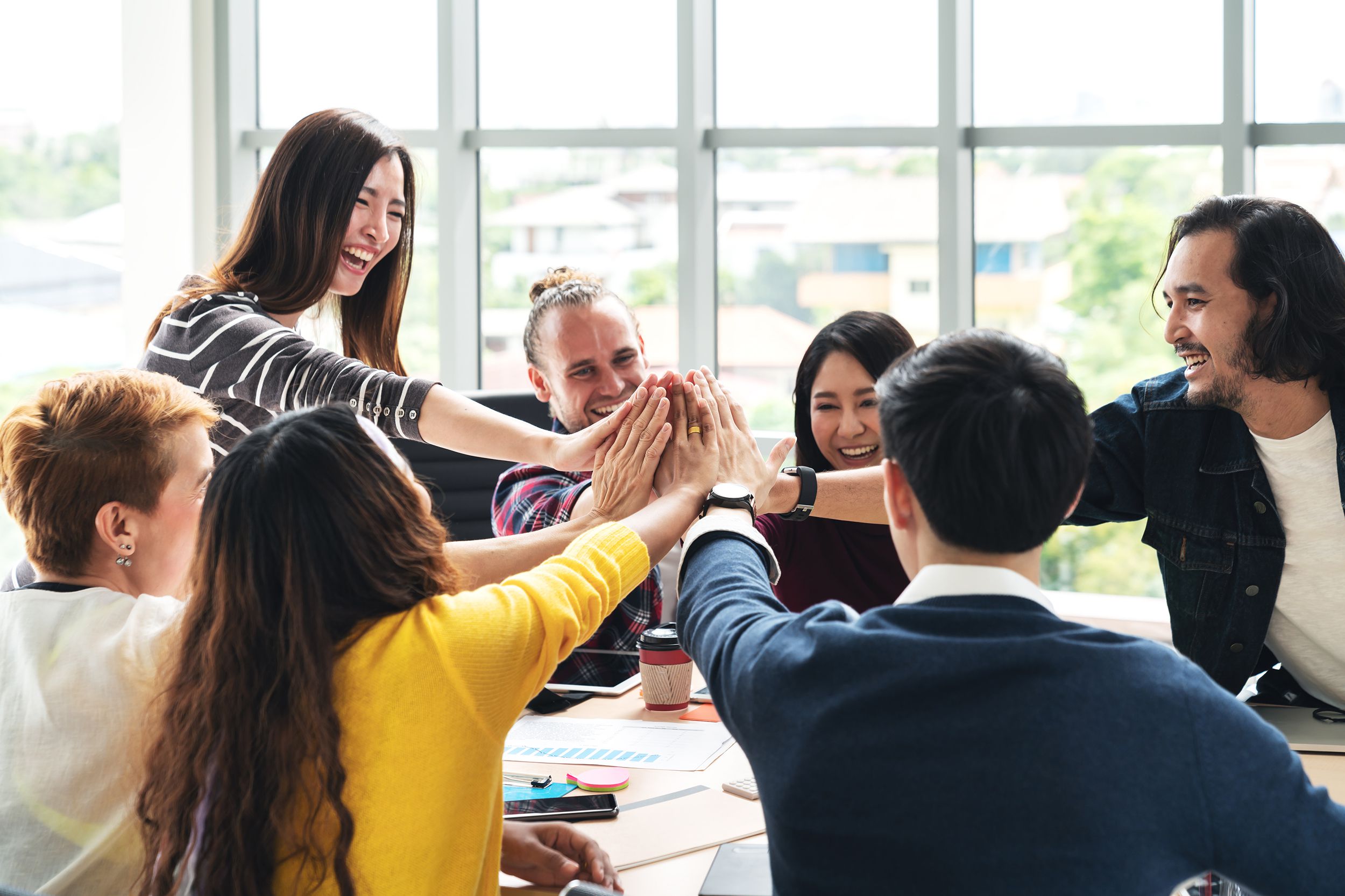group of young multiethnic diverse people gesture hand high five