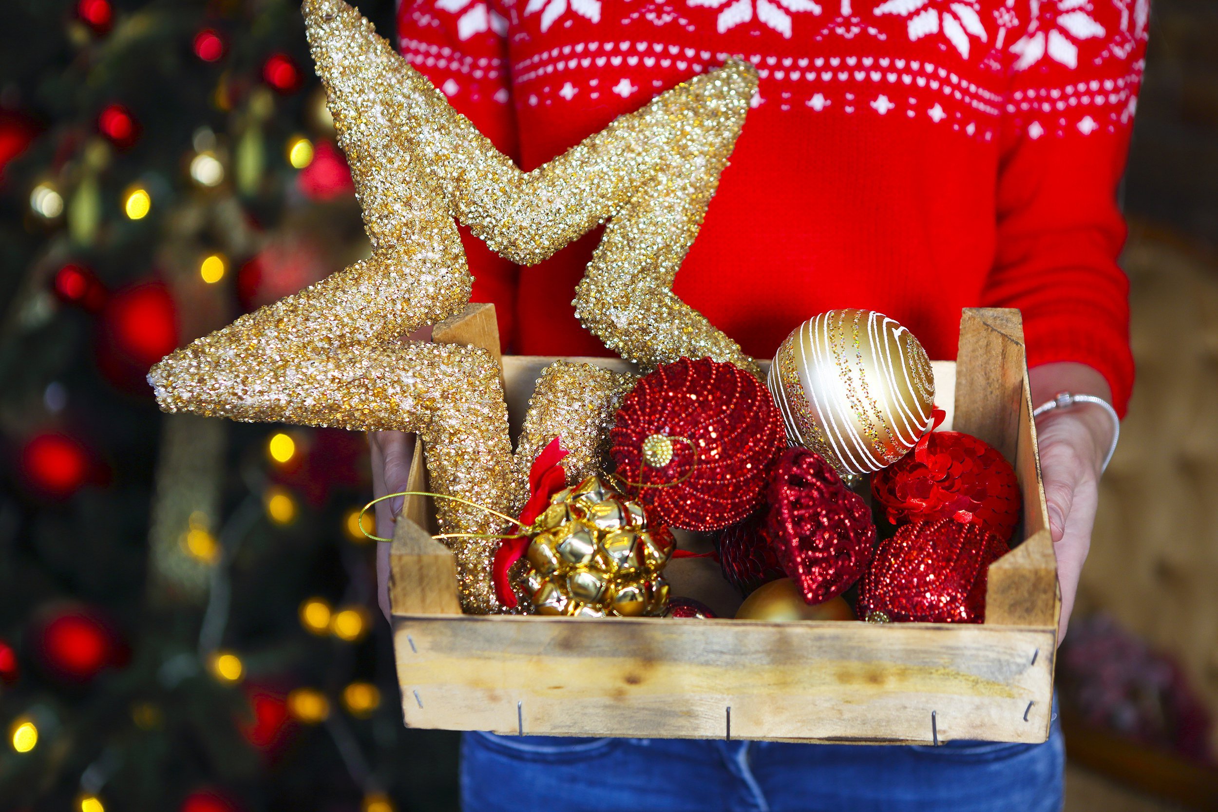 Person holding Christmas ornaments in a box