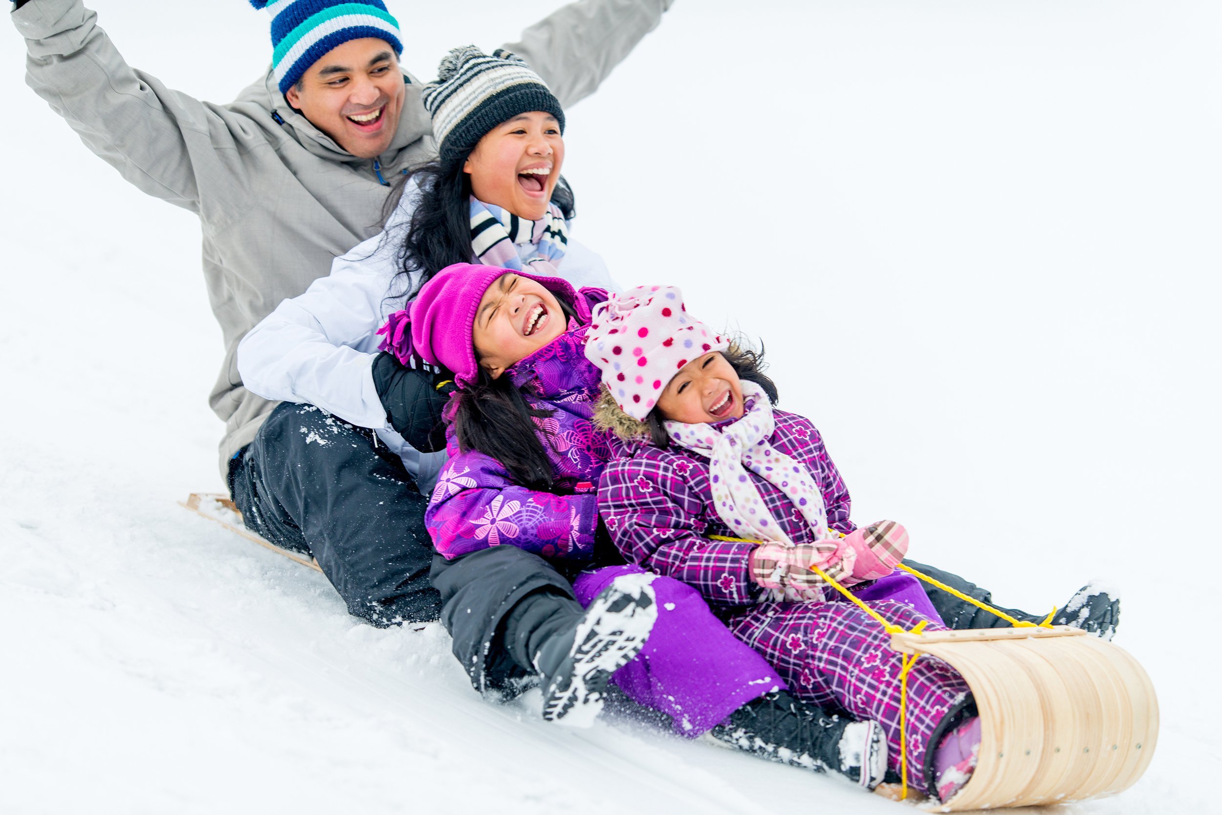 Family sledding in the snow