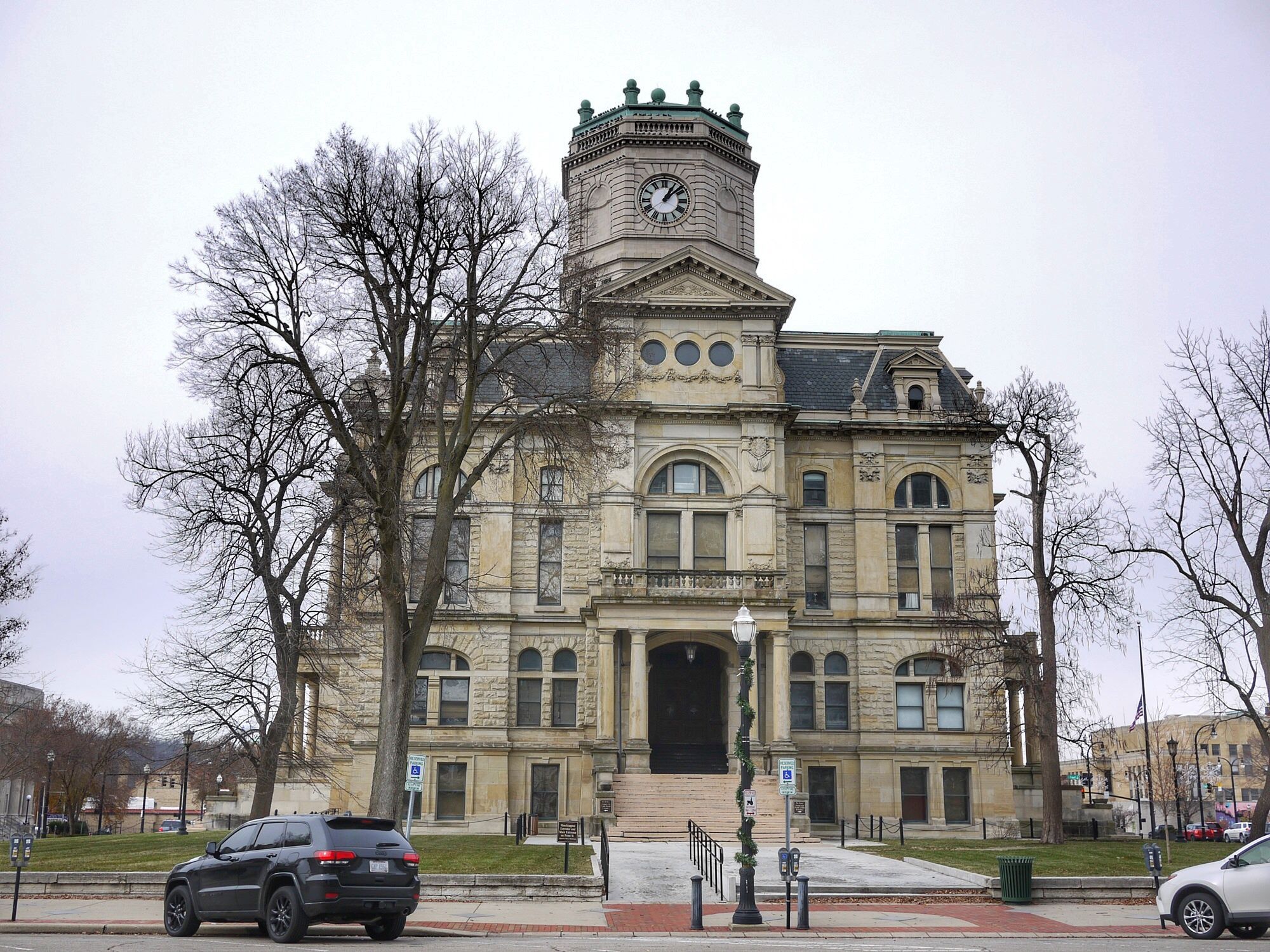 Historical building in downtown Hamilton, Ohio, during winter, with cars parked in front, and other historical buildings in the background