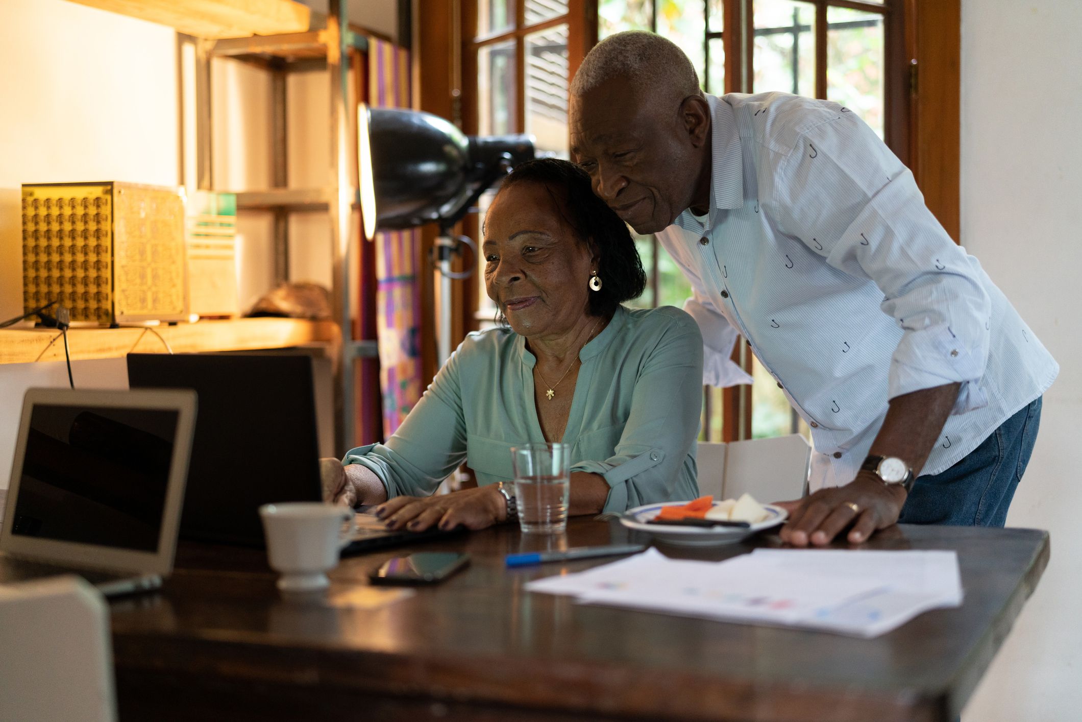 senior couple in home looking at laptop